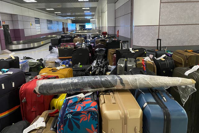 <p>Luggage stacked up at Manchester Airport last night</p>