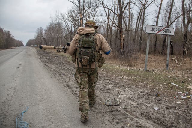 A Ukrainian serviceman walks next to a road sign in Chernobyl (Oleksandr Ratushniak/AP/PA)