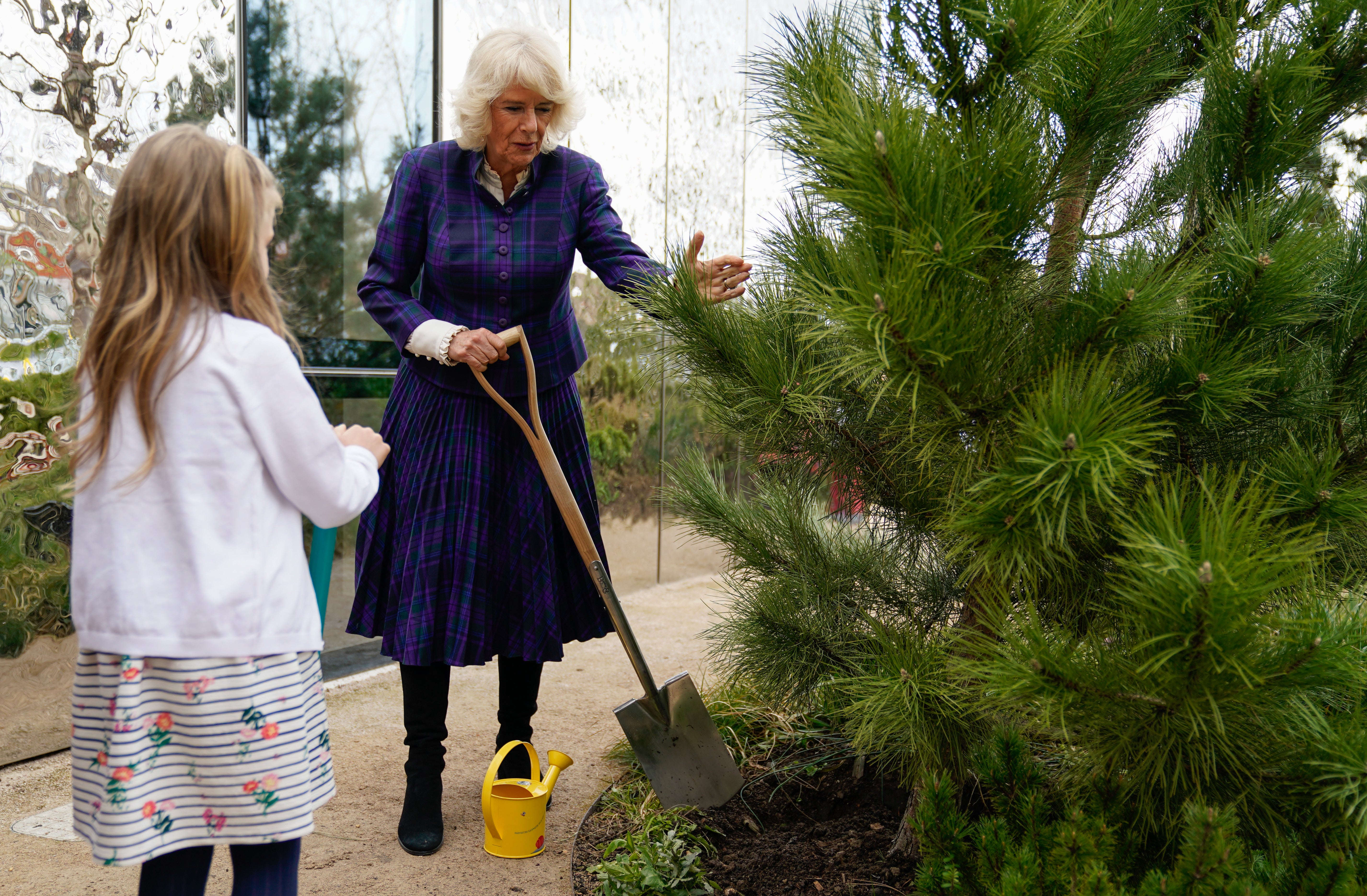 The Duchess of Cornwall helps plant a tree with Isabelle Hewson during a visit to the charity Maggie’s Southampton in the grounds of University Hospital Southampton (Andrew Matthews/PA)