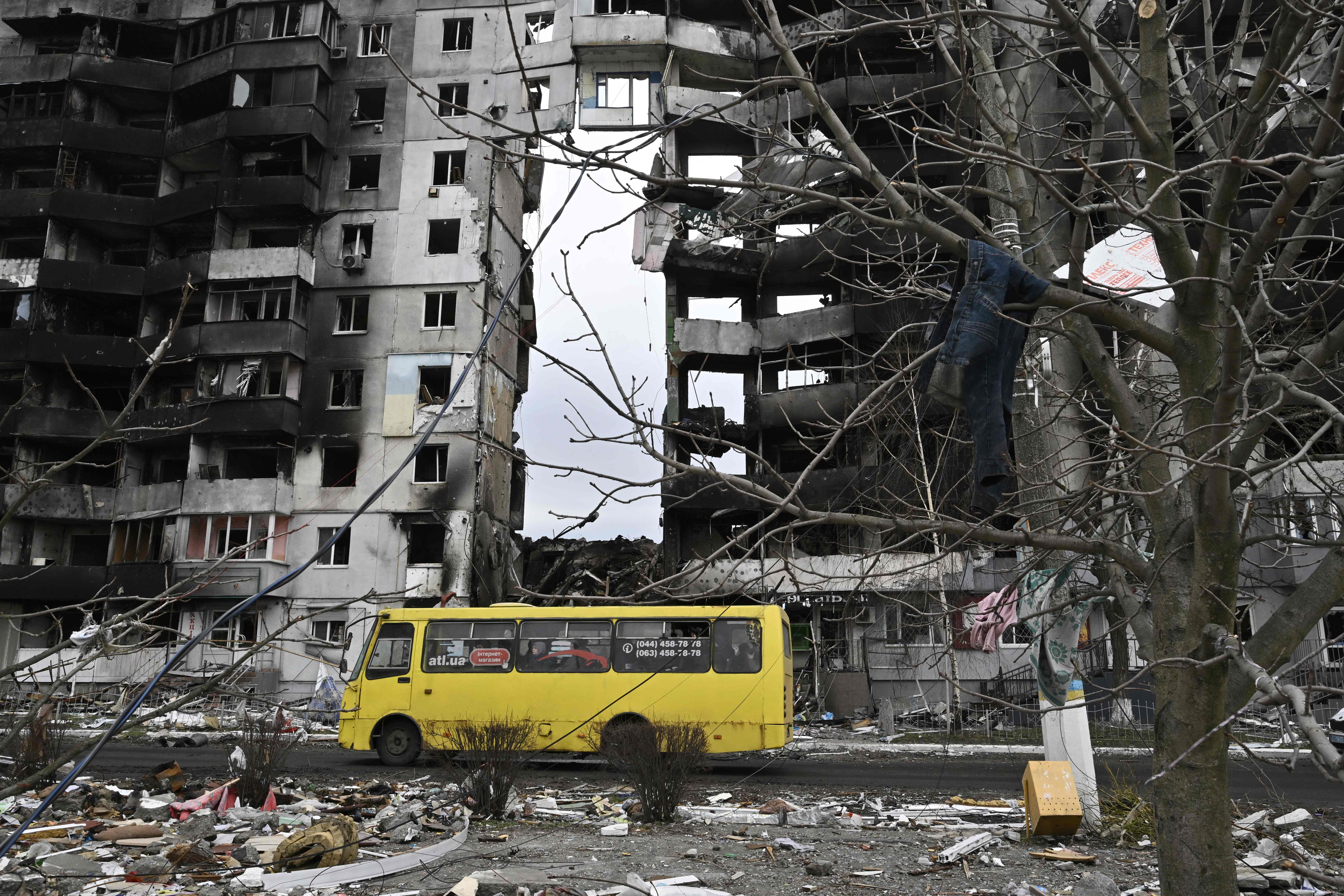 A bus passes by a destroyed building in the town of Borodianka, northwest of Kyiv