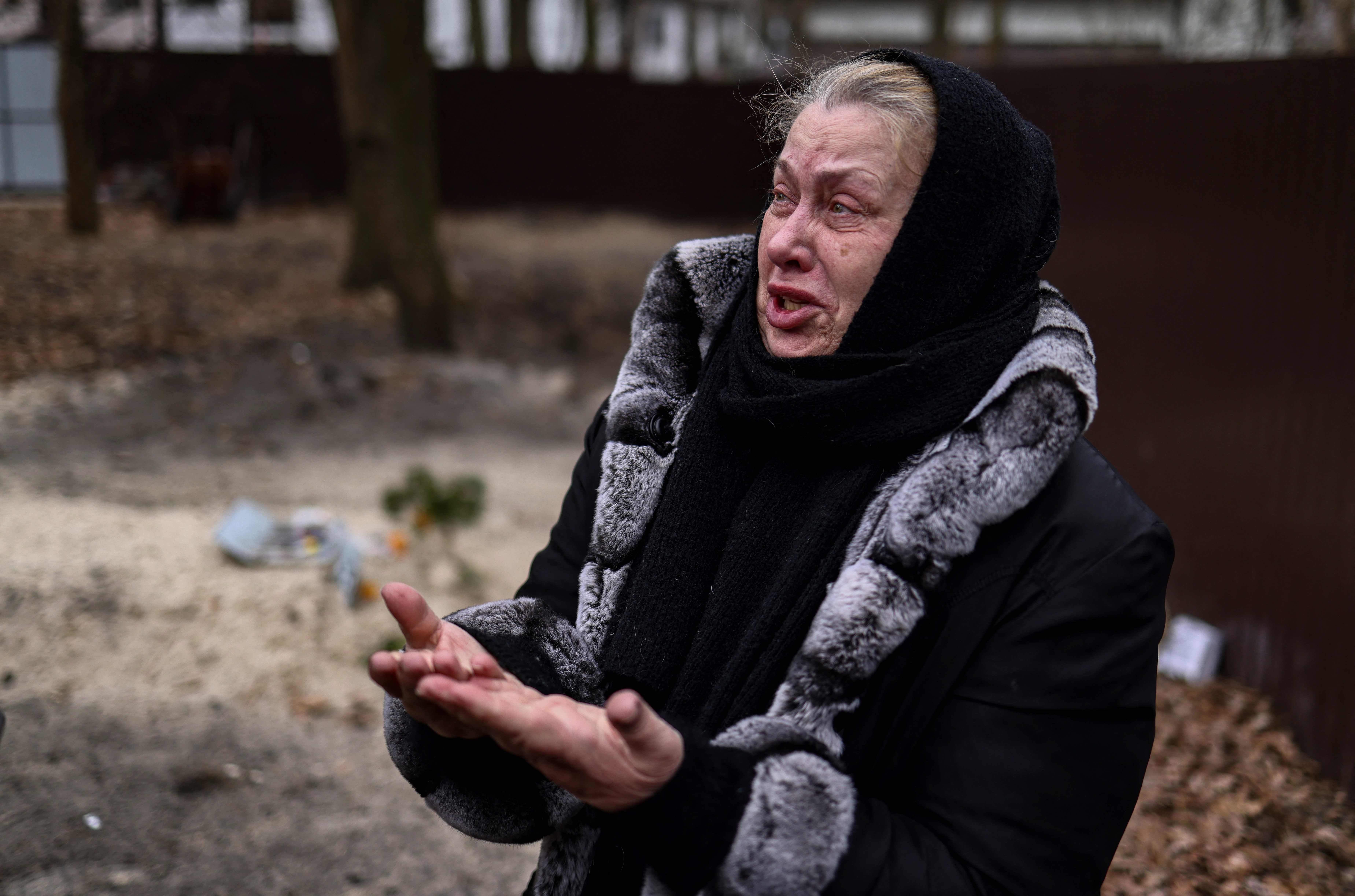 Bucha resident Tetiana Ustymenko weeps over the grave of her son, buried in the garden of her house