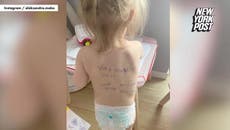 Ukrainian mother writes phone number on daughter’s back in case they become separated