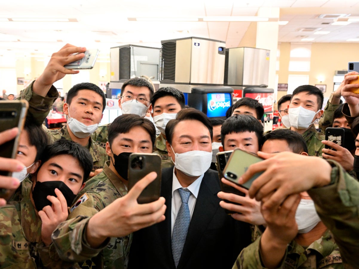 South Korean president-elect Yoon Suk Yeol, centre, poses for selfies with soldiers