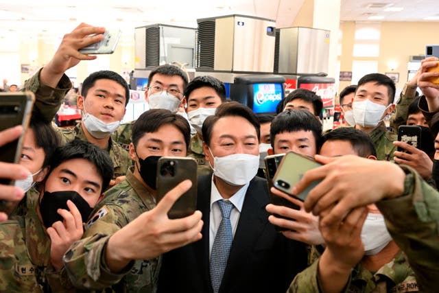 <p>South Korean president-elect Yoon Suk Yeol, centre, poses for selfies with soldiers </p>