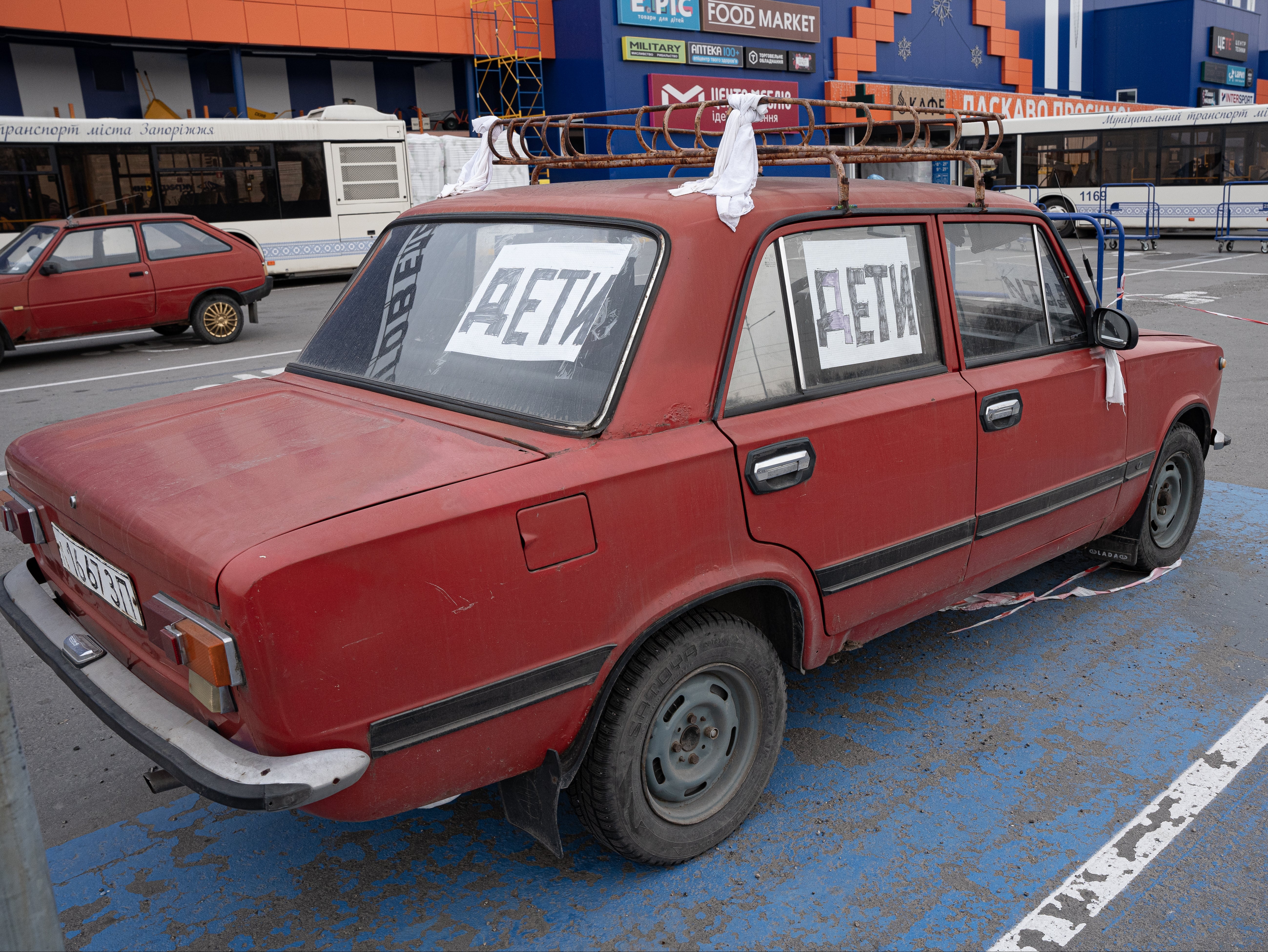 Volunteers tie white rags to the door handles of their cars and write the word ‘children’ in Russian to help protect the civilians they rescue from Mariupol