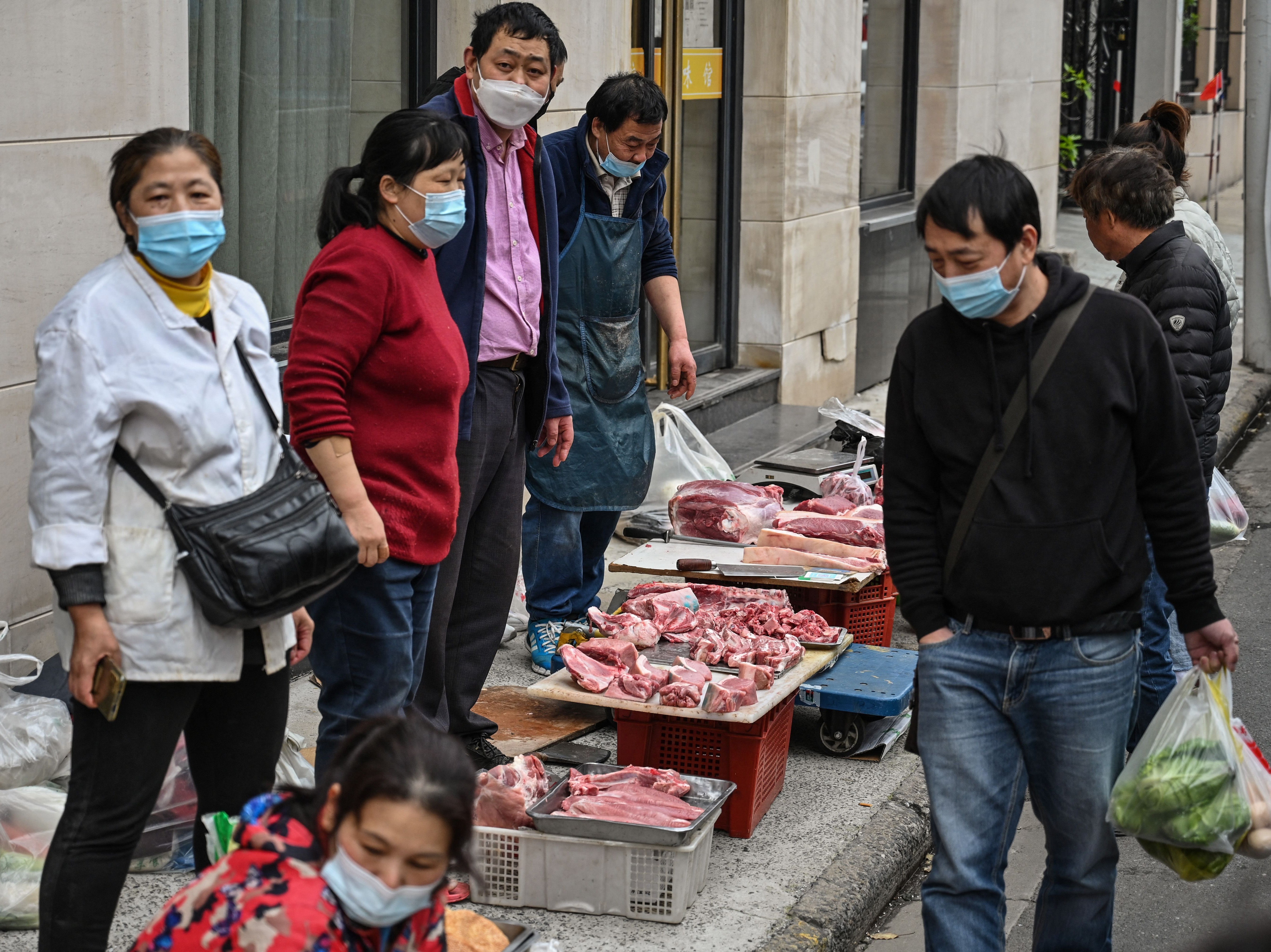 Vendors sell meat in front of a local market in Shanghai’s Jing’an district on 31 March