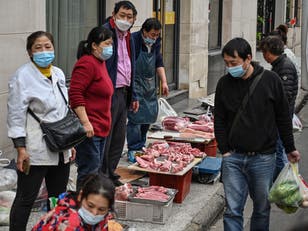 <p>Vendors sell meat in front of a local market in Shanghai’s Jing’an district on 31 March</p>
