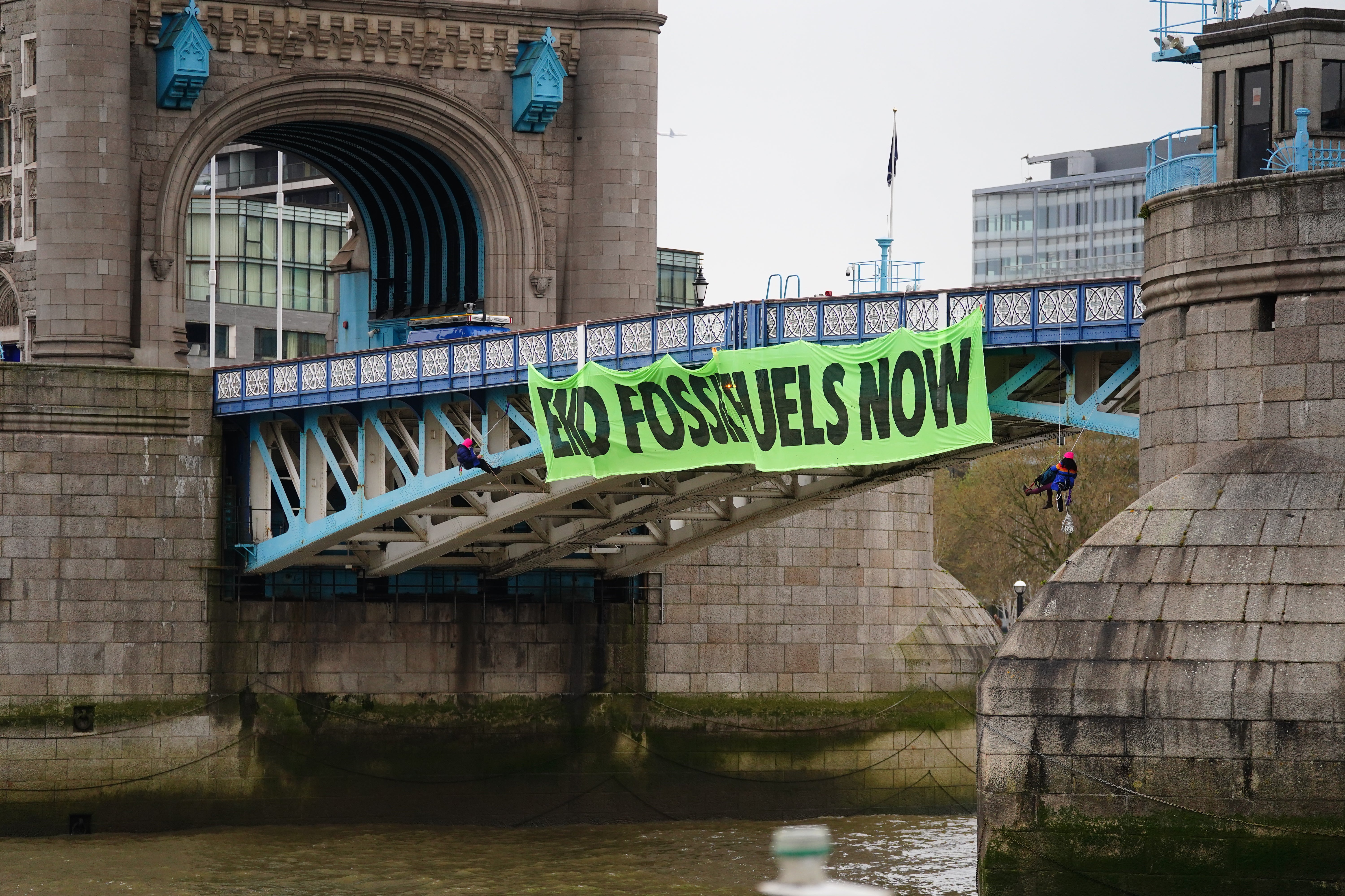 Activists from Extinction Rebellion hung from suspension cords (Victoria Jones/PA)