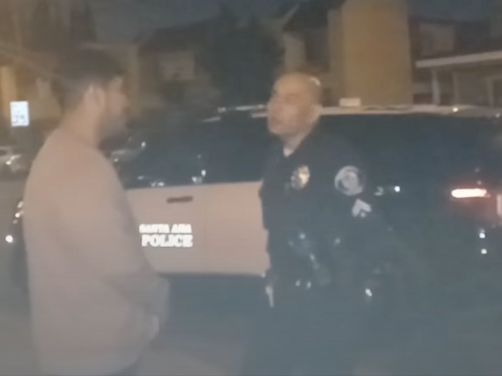 <p>A Santa Ana council member and police officer discussing the songs being played </p>