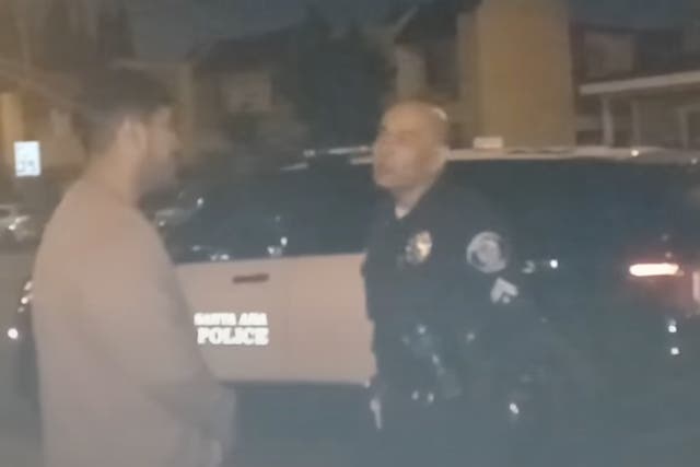 <p>A Santa Ana council member and police officer discussing the songs being played </p>