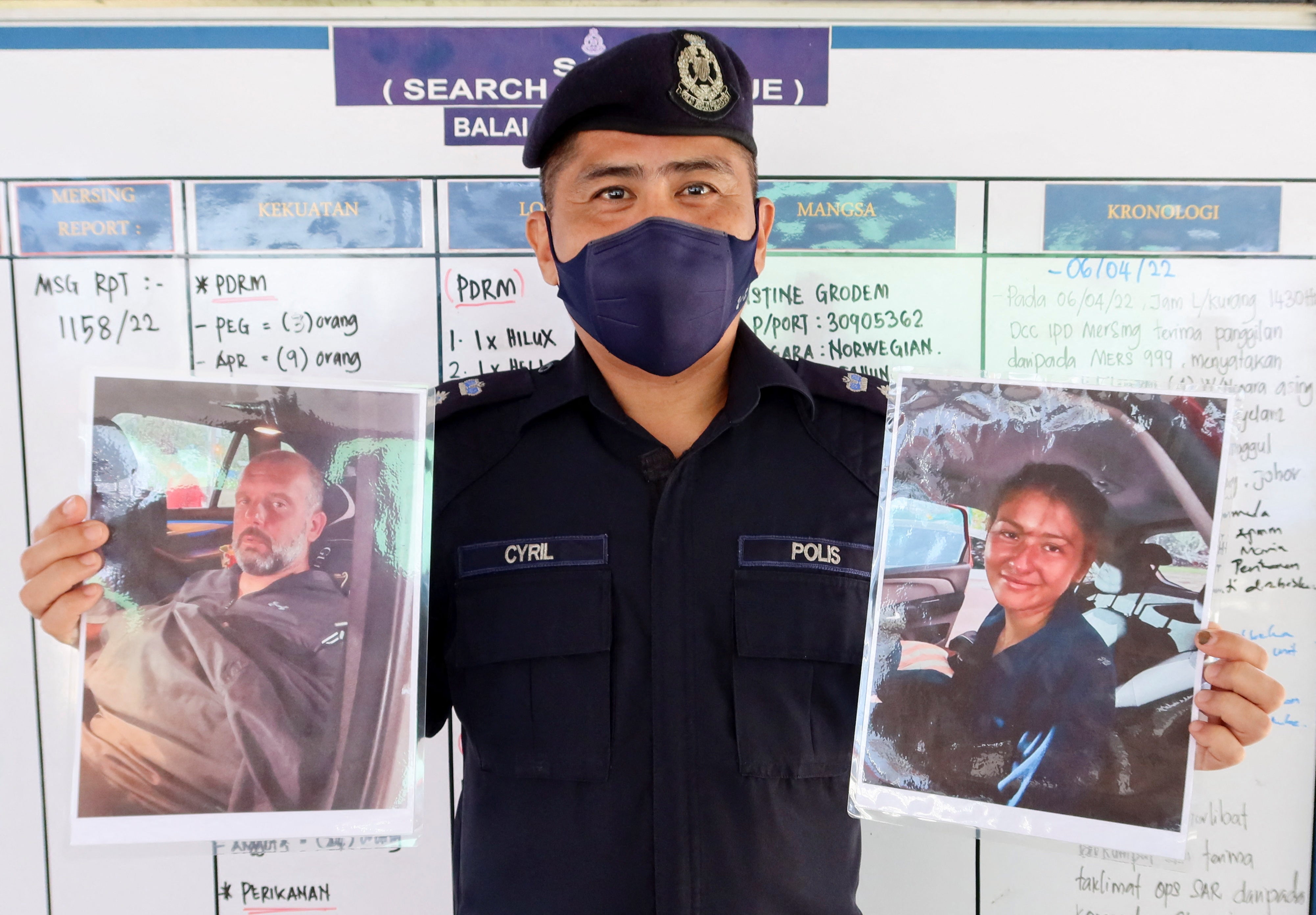 A Mersing district police officer shows the pictures of Adrian Peter Chesters and Alexia Molina, who were rescued at around 1am on Saturday