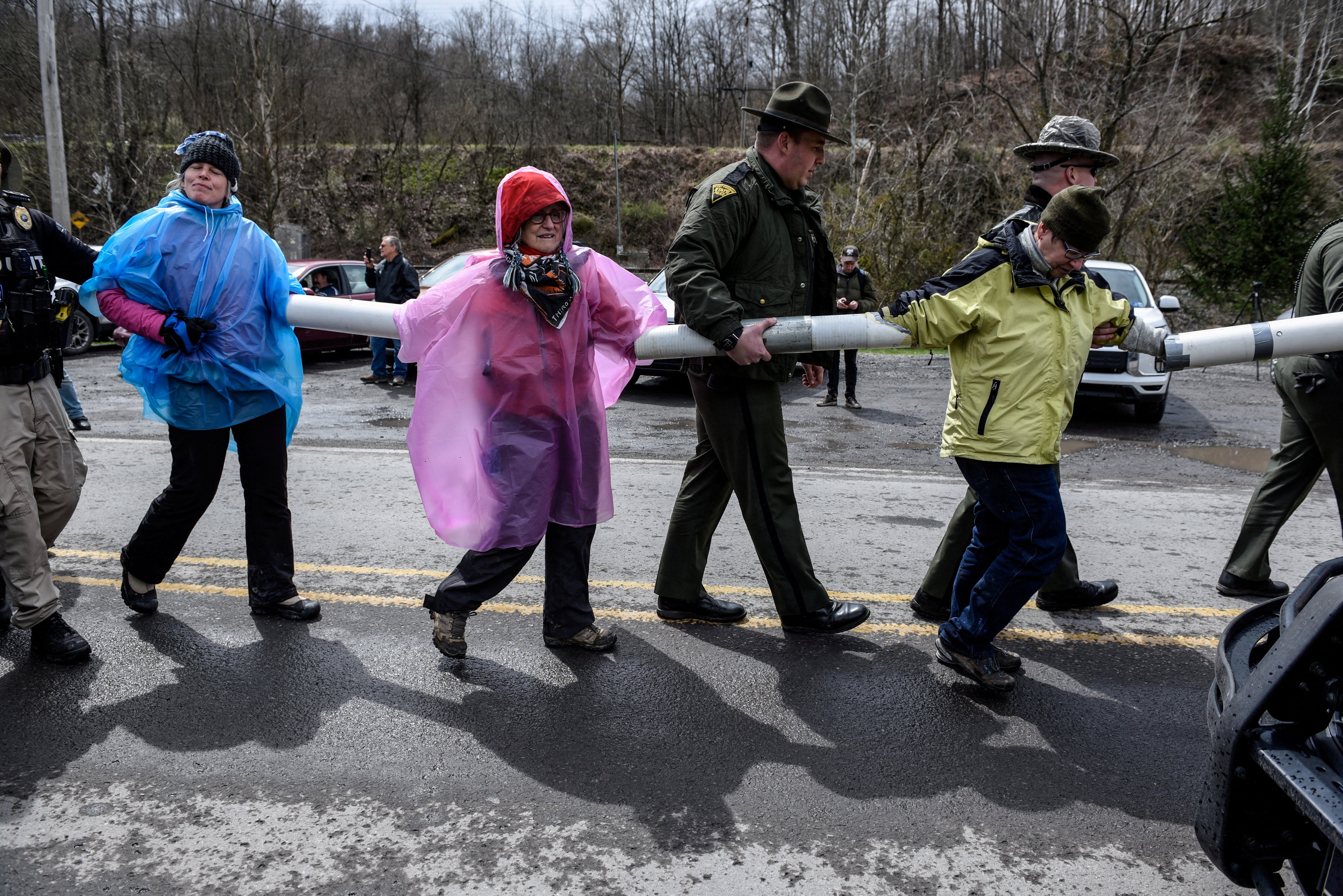 Police lead people away who are chained together during a protest against Senator Joe Manchin as they blockade the Grant Town Coal Waste Power Plant in Grant Town, West Virginia