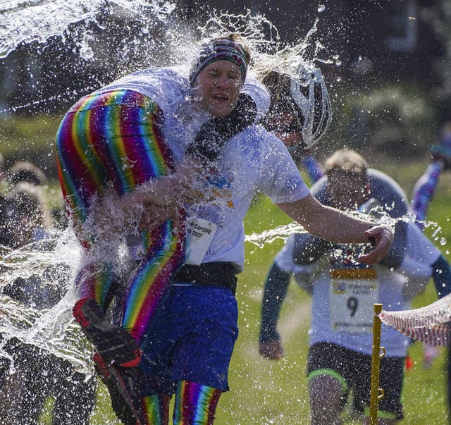 Competitors take part in the annual UK Wife Carrying Race (Steve Parsons/PA)