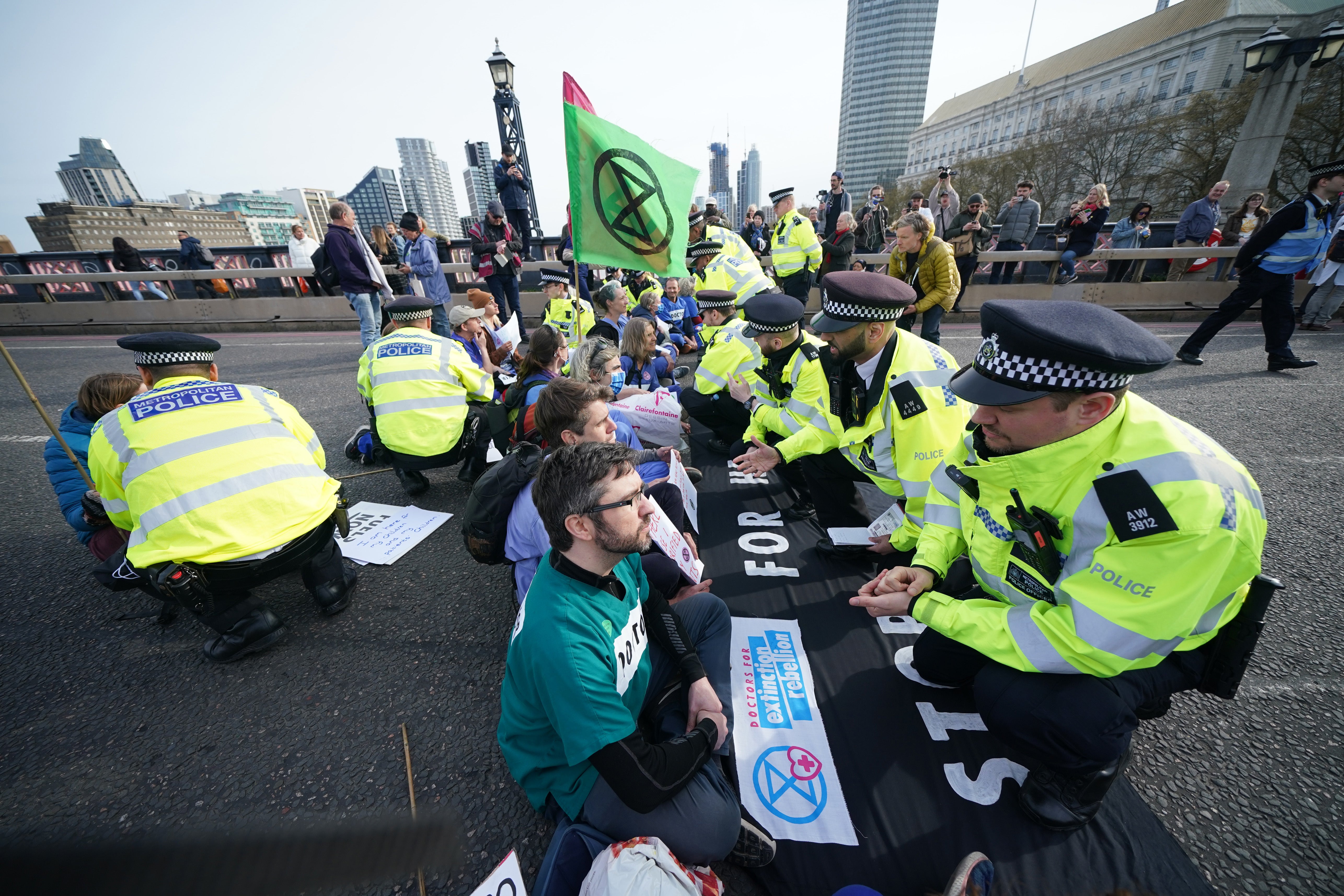 Police talk to protestors taking part in a demonstration on Lambeth Bridge in central London (Yui Mok/PA)