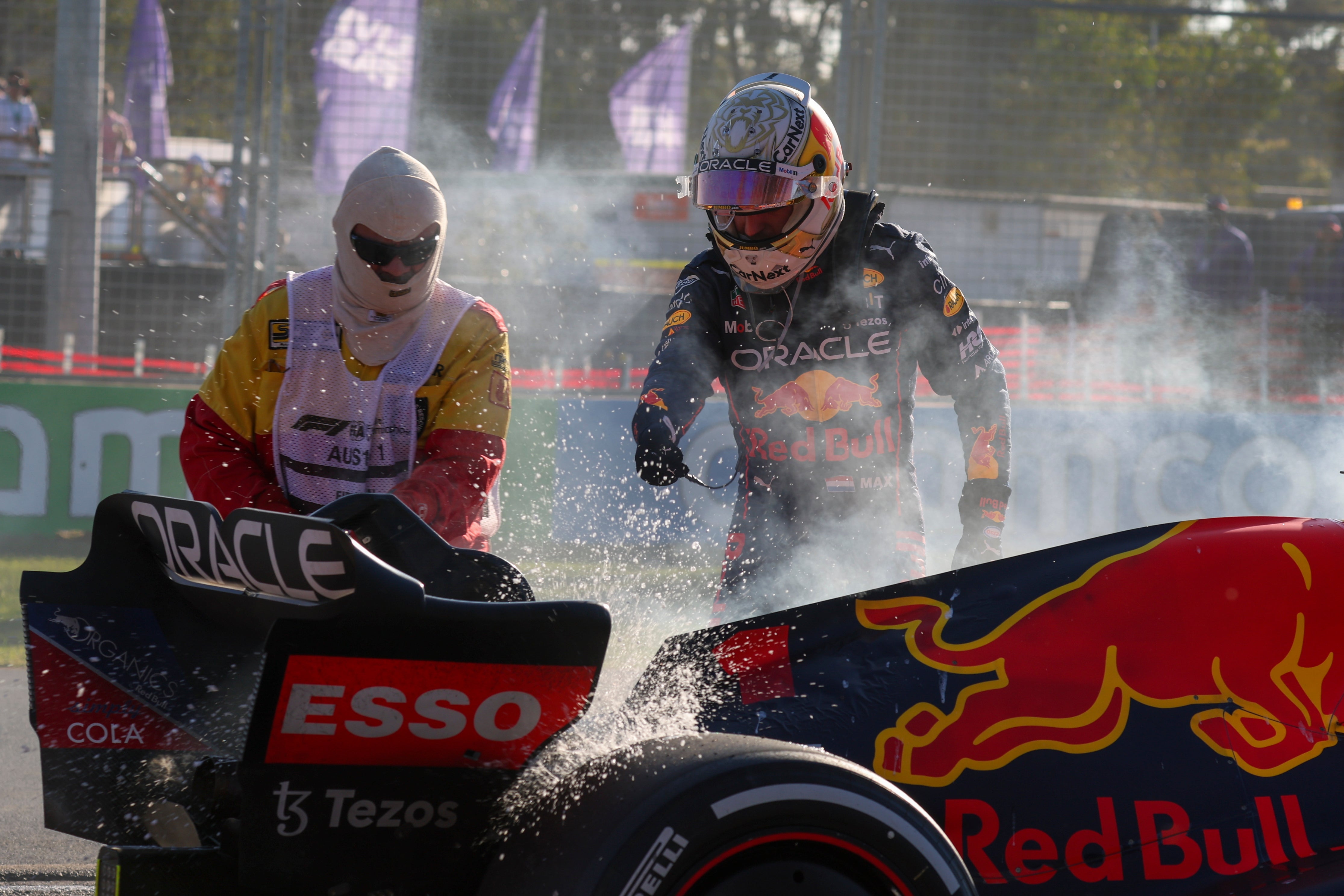 Red Bull’s Max Verstappen looks on as a fire in his car is extinguished during the Australian Grand Prix in Melbourne, which was won by Ferarri’s Charles Leclerc