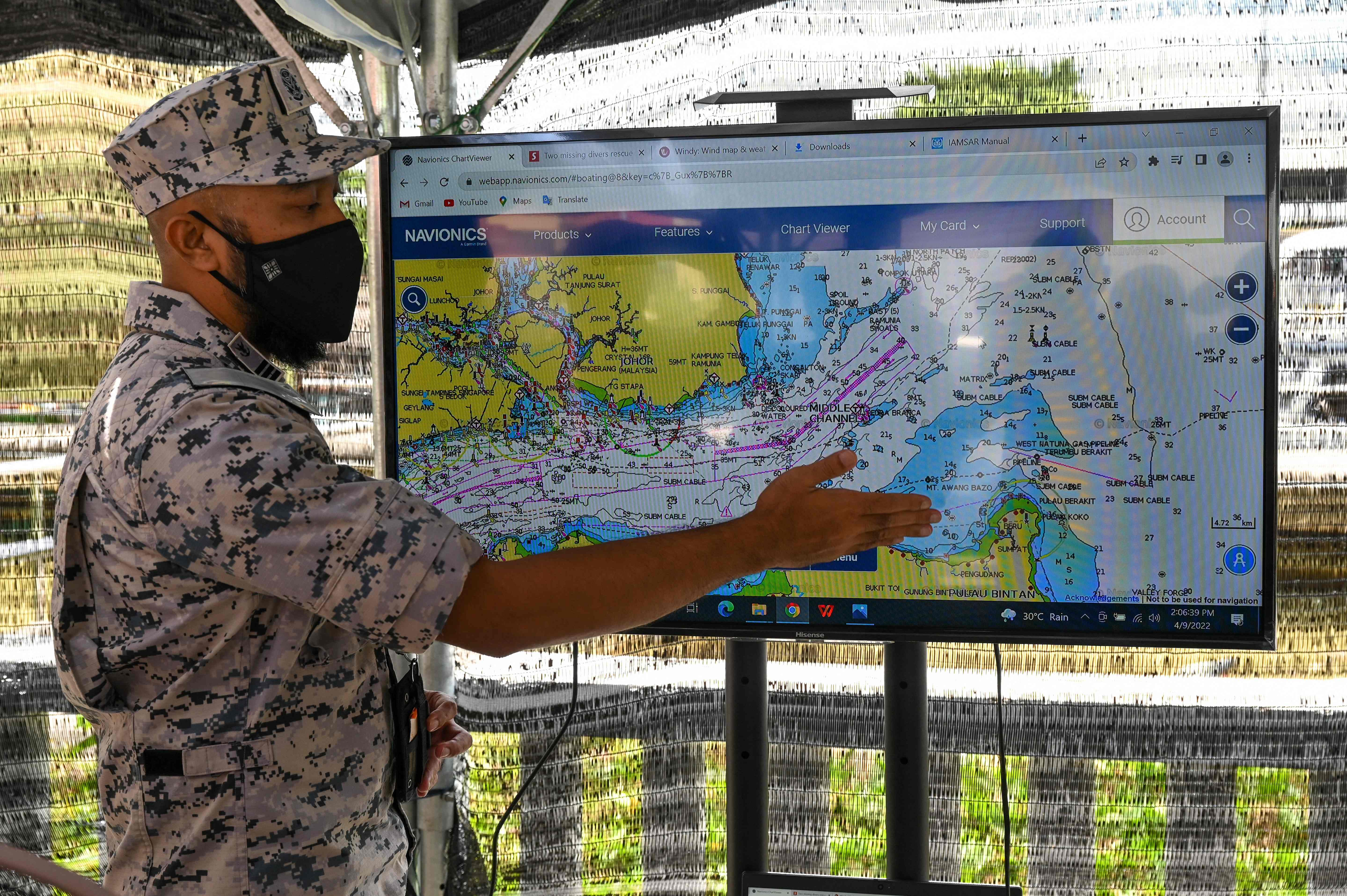 Commander of the Malaysian Maritime Enforcement Khairul Nizam Misran shows on a map where two divers, French national Alexia Alexandra Molina and British national Adrian Peter Chesters, were found alive near Indonesia’s Bintan Island on 9 April 2022