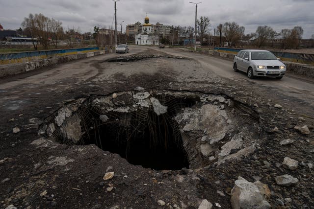 Cars drive near a damaged bridge following a Russian attack in the previous weeks in the town of Makarov, Kyiv region, Ukraine, on Sunday, April 10, 2022. (AP Photo/Petros Giannakouris)