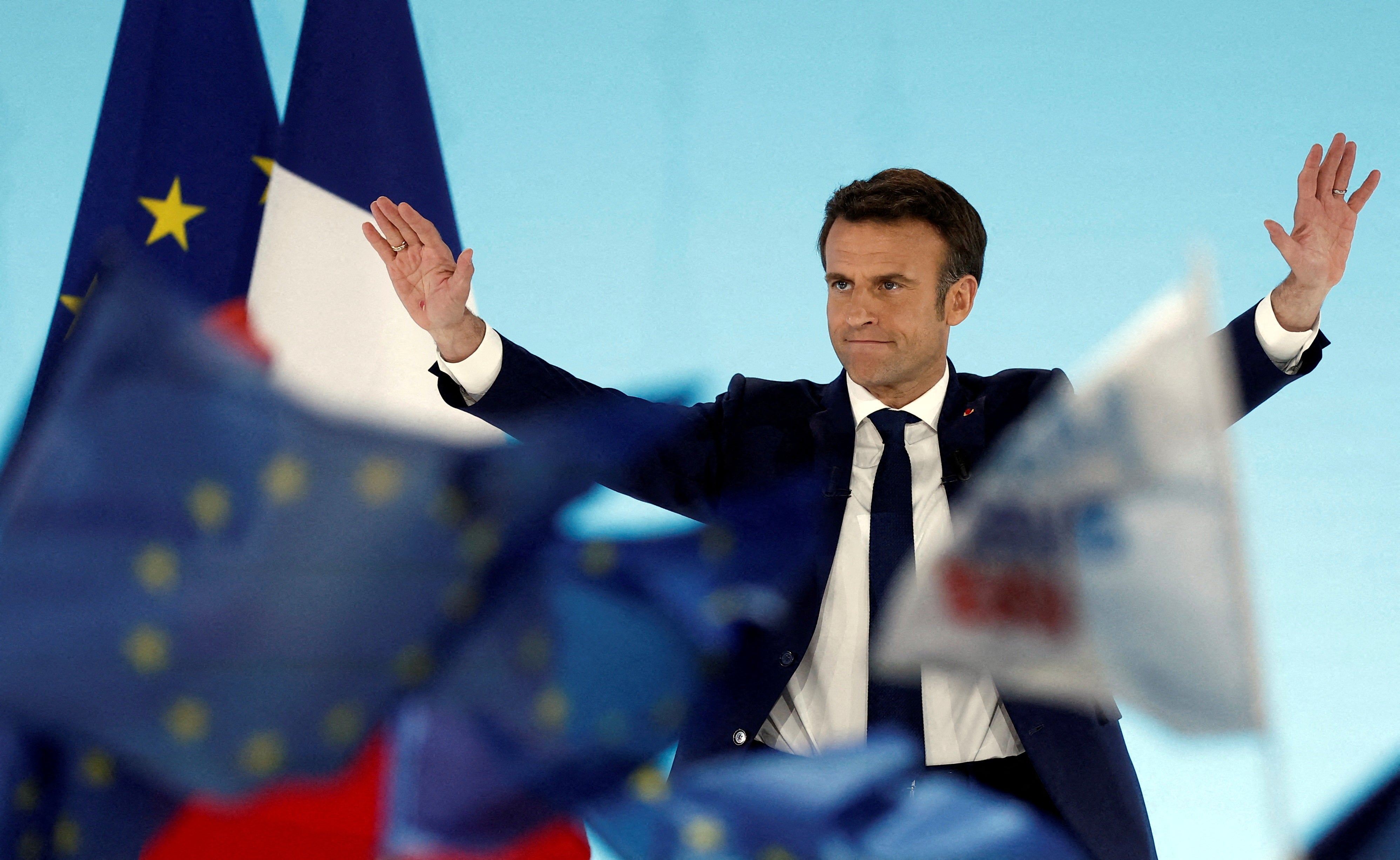 Emmanuel Macron reacts on stage after partial results were announced on Sunday evening