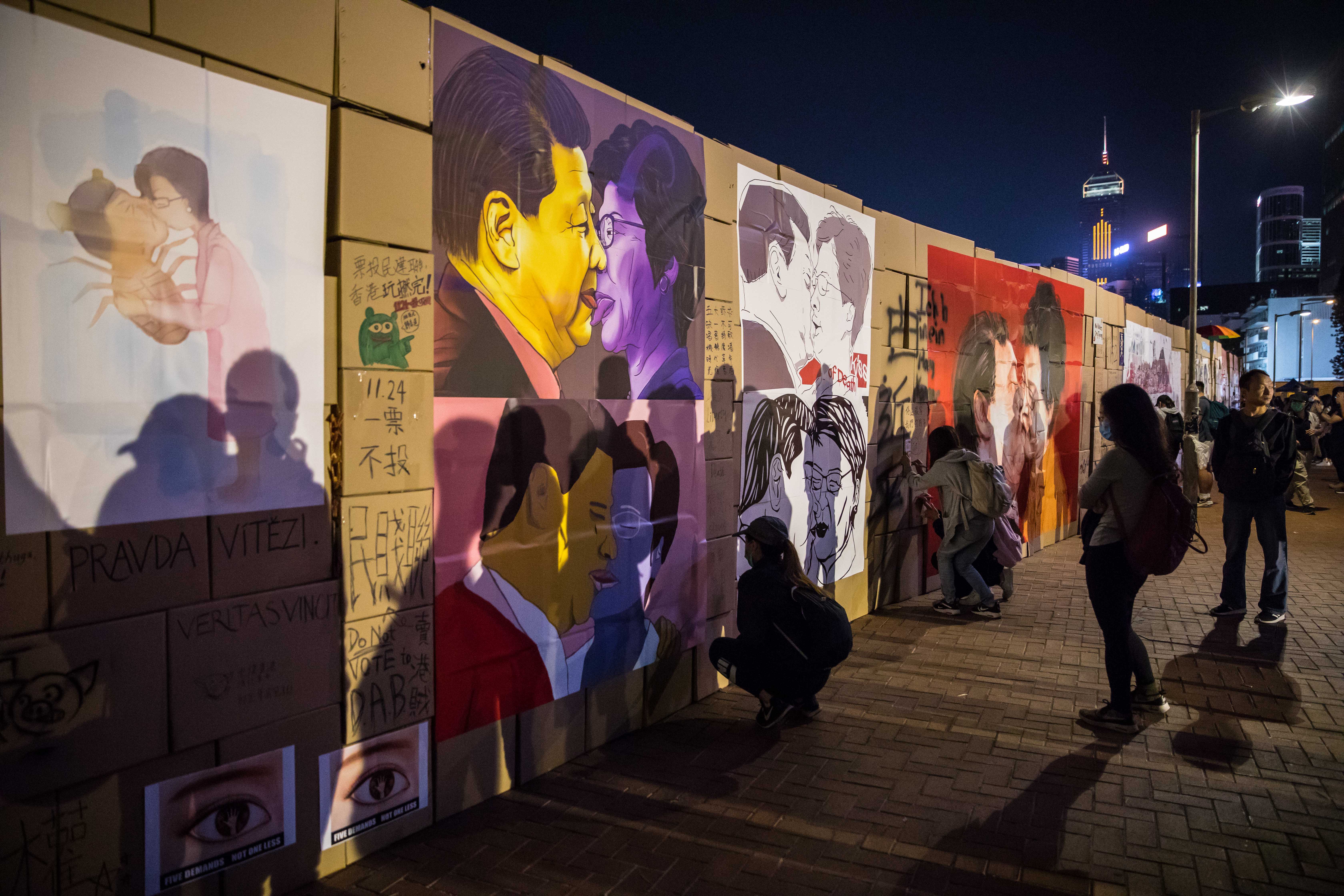 A wall made of cardboard boxes with images of China’s president Xi Jinping and Carrie Lam