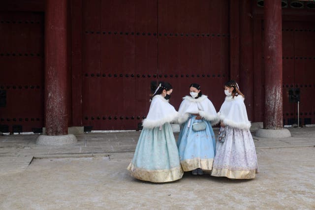 <p>Visitors wear traditional hanbok dress on the grounds of the Gyeongbokgung Palace in Seoul on 17 January 2022</p>