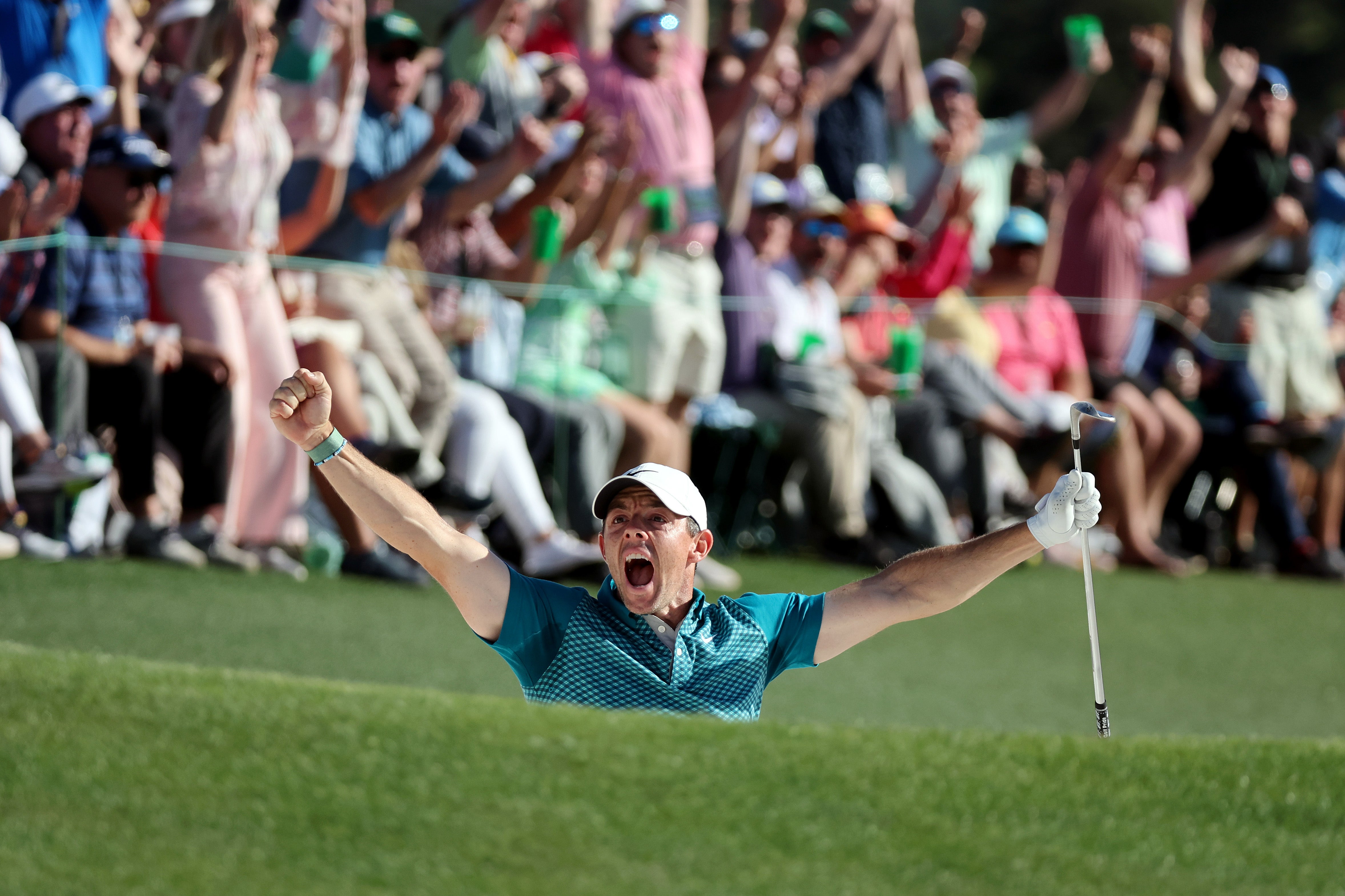 Rory McIlroy celebrates chippig in from the bunker on 18