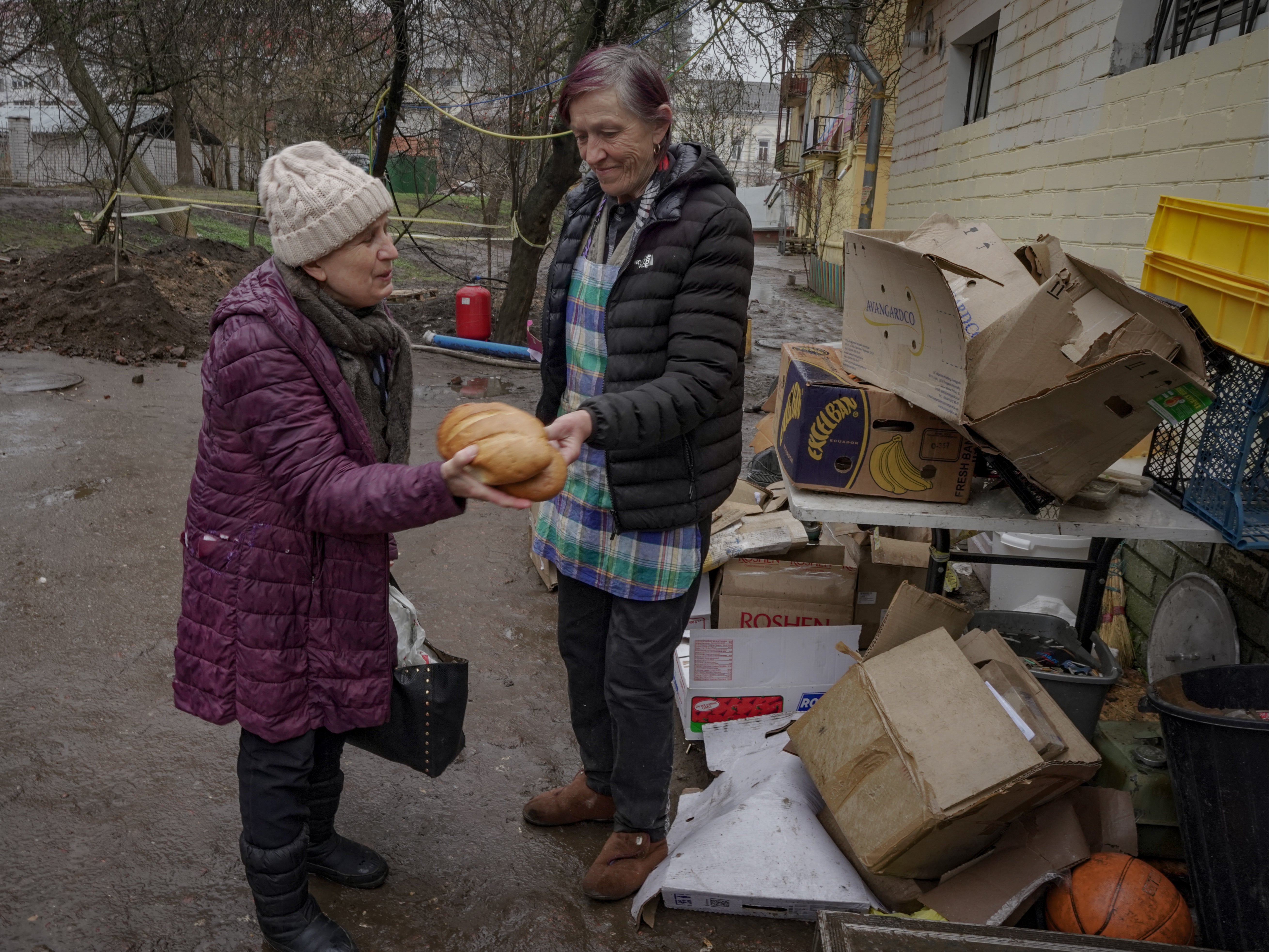 ‘If it wasn’t for them, I don’t think I would be here’: Maria (left) is given bread by the charity in Chernihiv