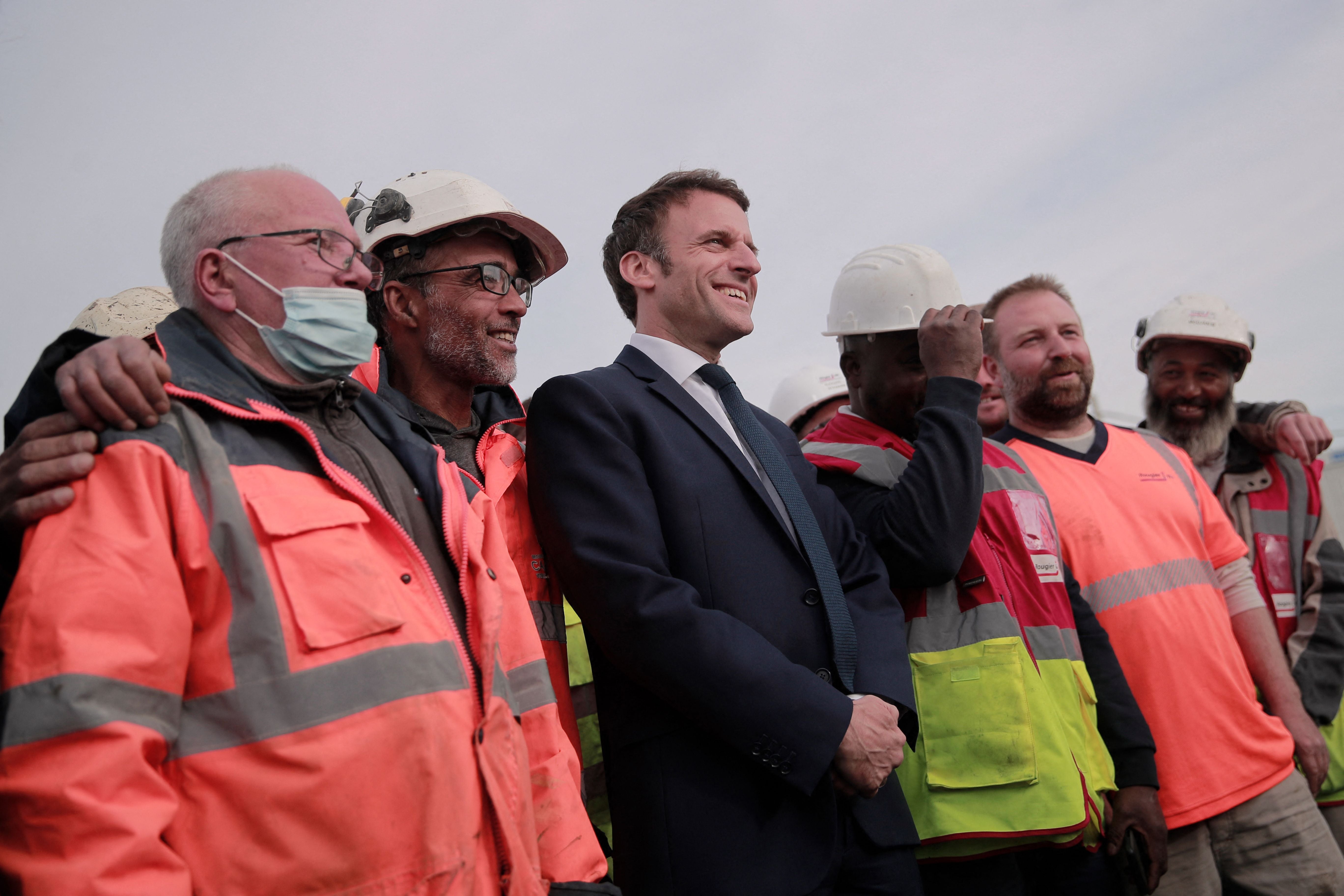 Emmanuel Macron poses with construction workers in Denain, northern France