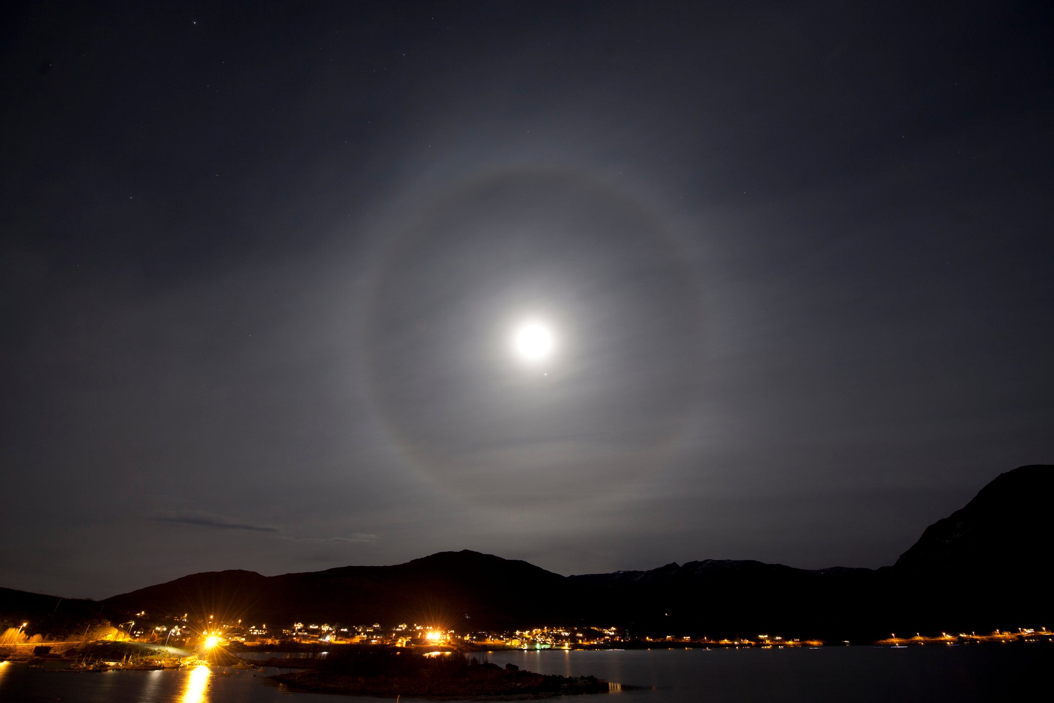 The moon with a halo over the city of Tromso in arctic Norway