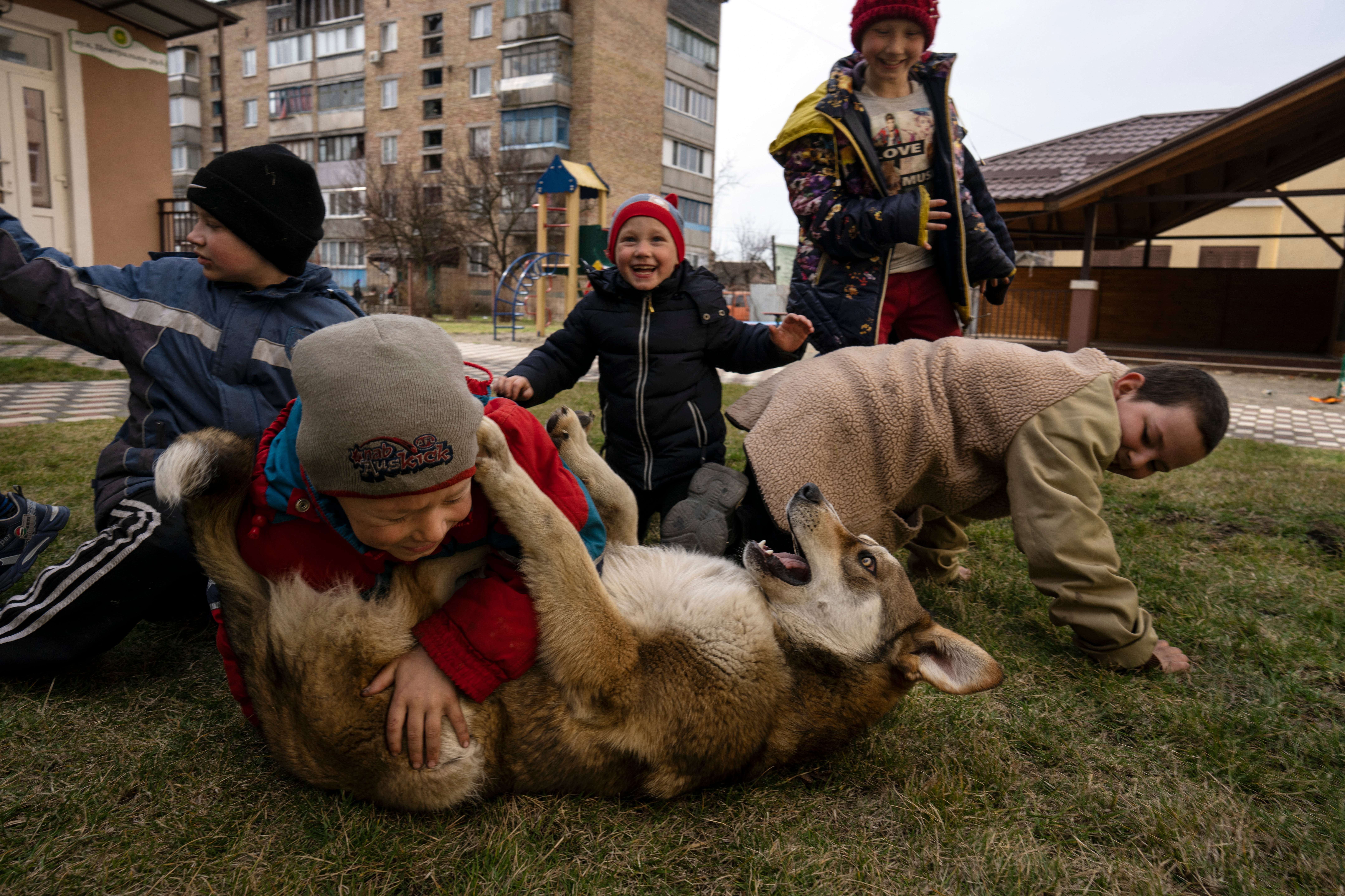Children play with a dog in Bucha, on the outskirts of Kyiv, Ukraine