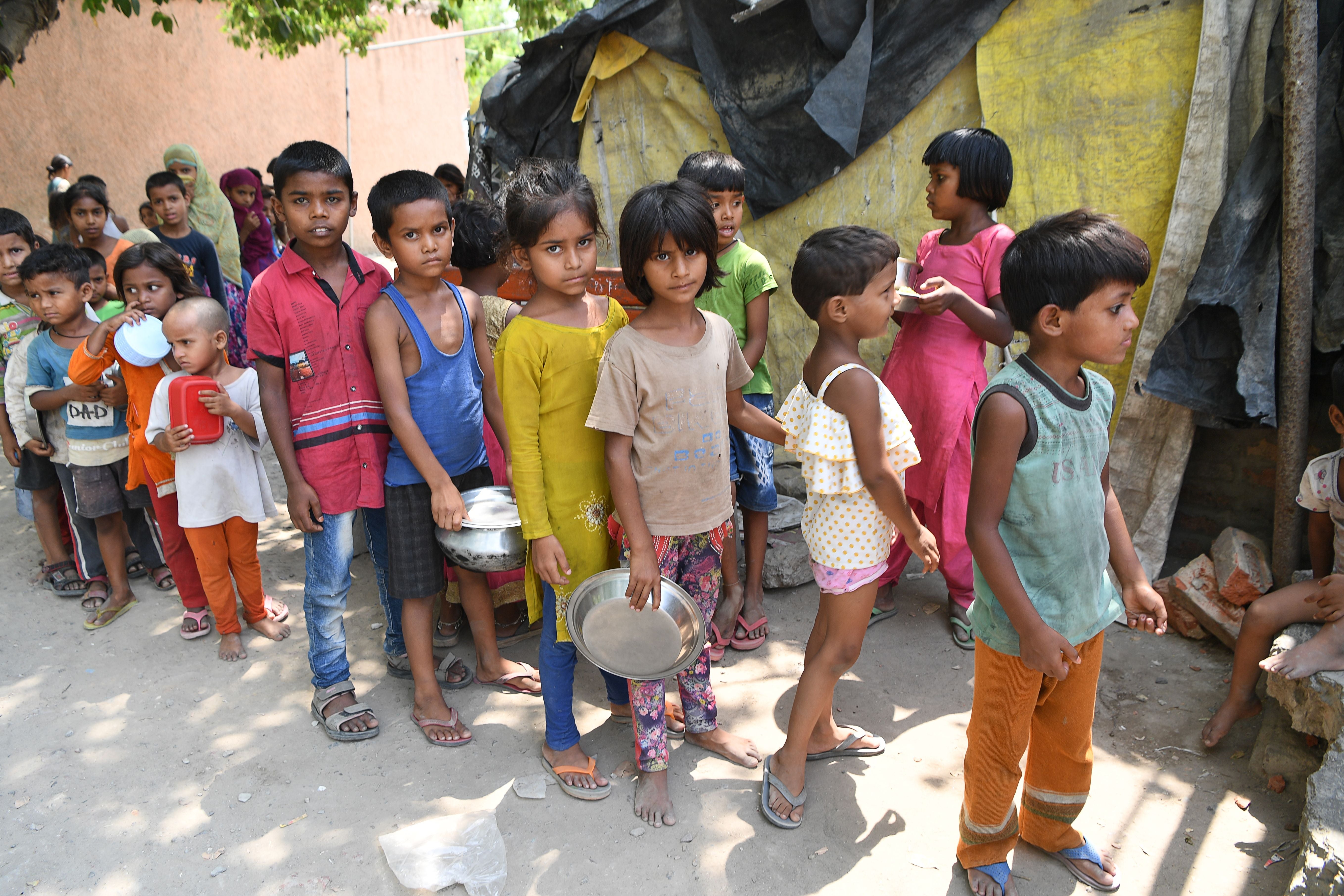 File: Children from a slum stand in queues to get free food after the government eased a nationwide lockdown against Covid-19 in Delhi