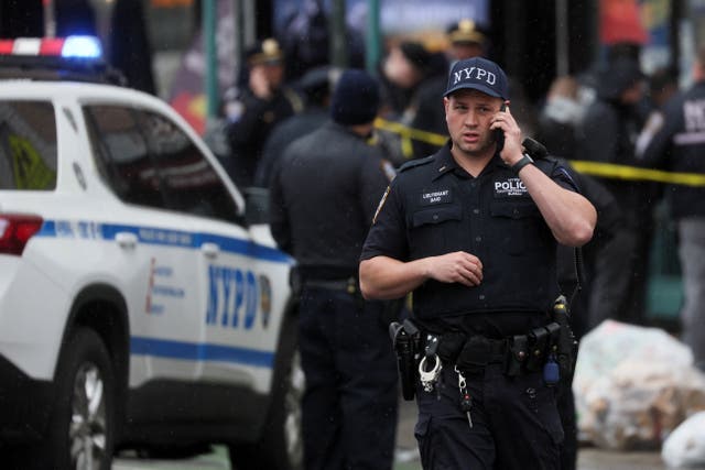 <p>A police officer works near the scene of a shooting at a subway station in the Brooklyn borough</p>
