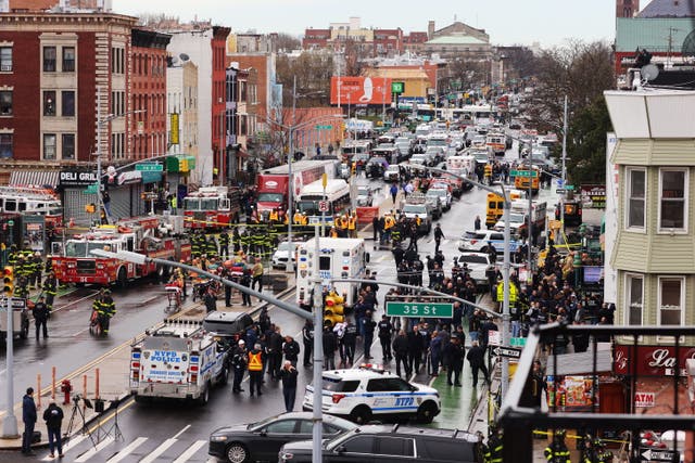 <p>Crowds surround law enforcement investigating a subway attack in Brooklyn on 12 April</p>