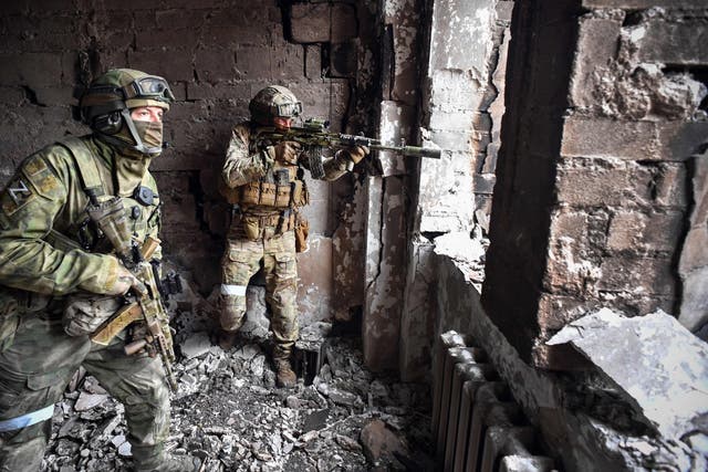 <p>Russian soldiers on patrol at the Mariupol drama theatre, which was hit by an airstrike in March </p>