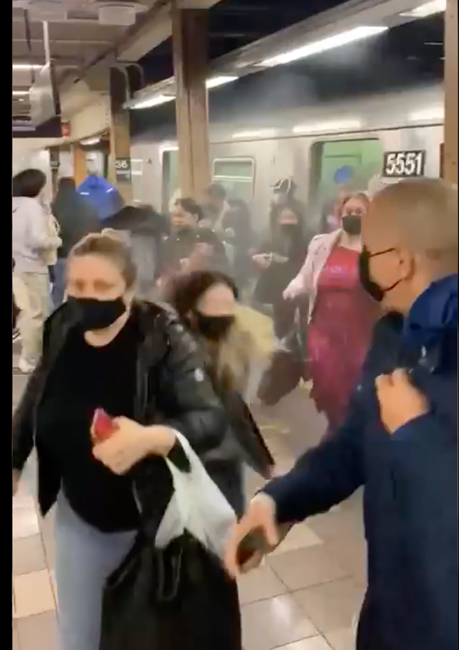 Subway riders check behind them as they flee from the Brooklyn subway shooting on Tuesday