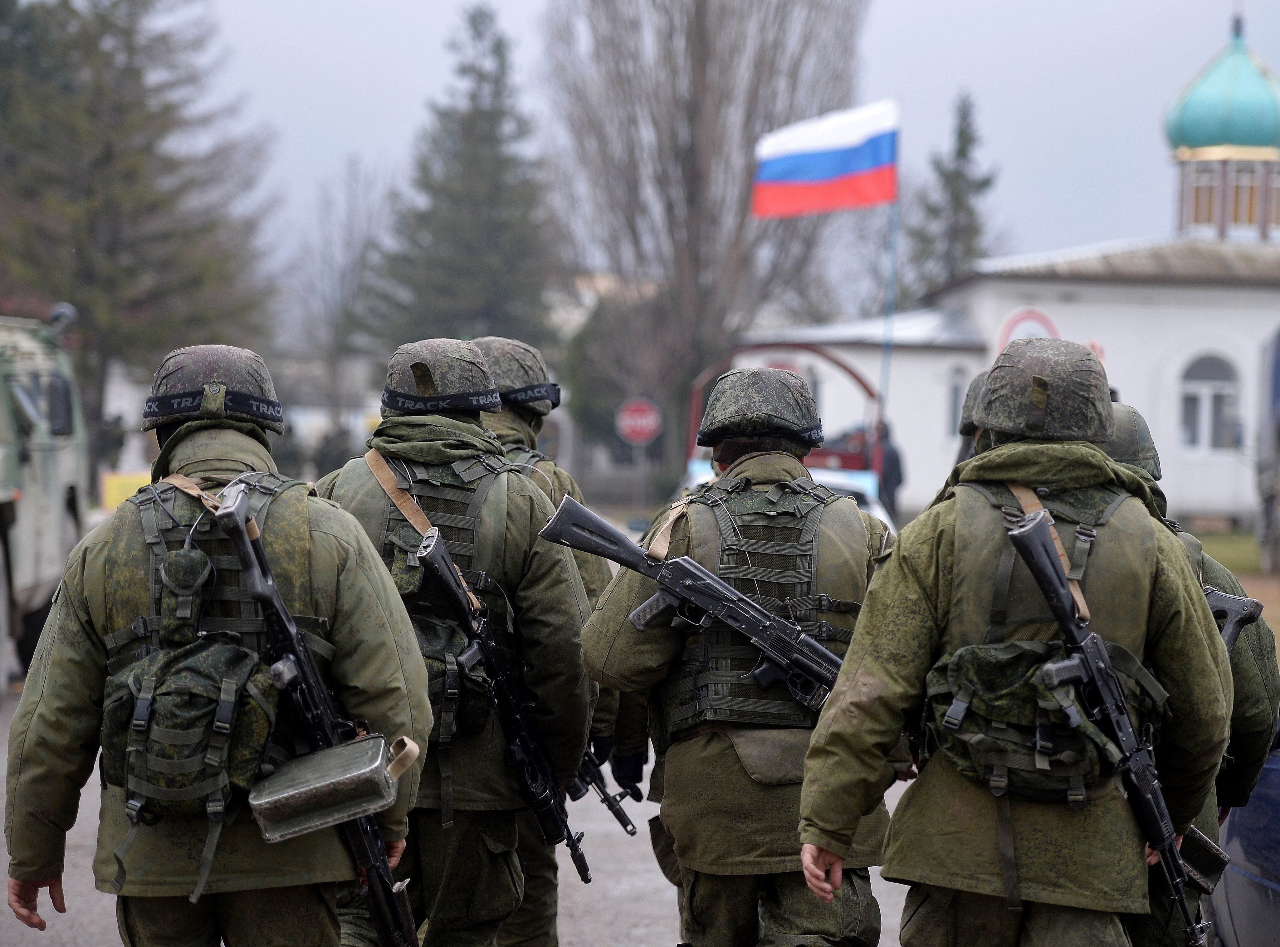 Russian soldiers patrol the area surrounding the Ukrainian military unit outside Simferopol, in 2014