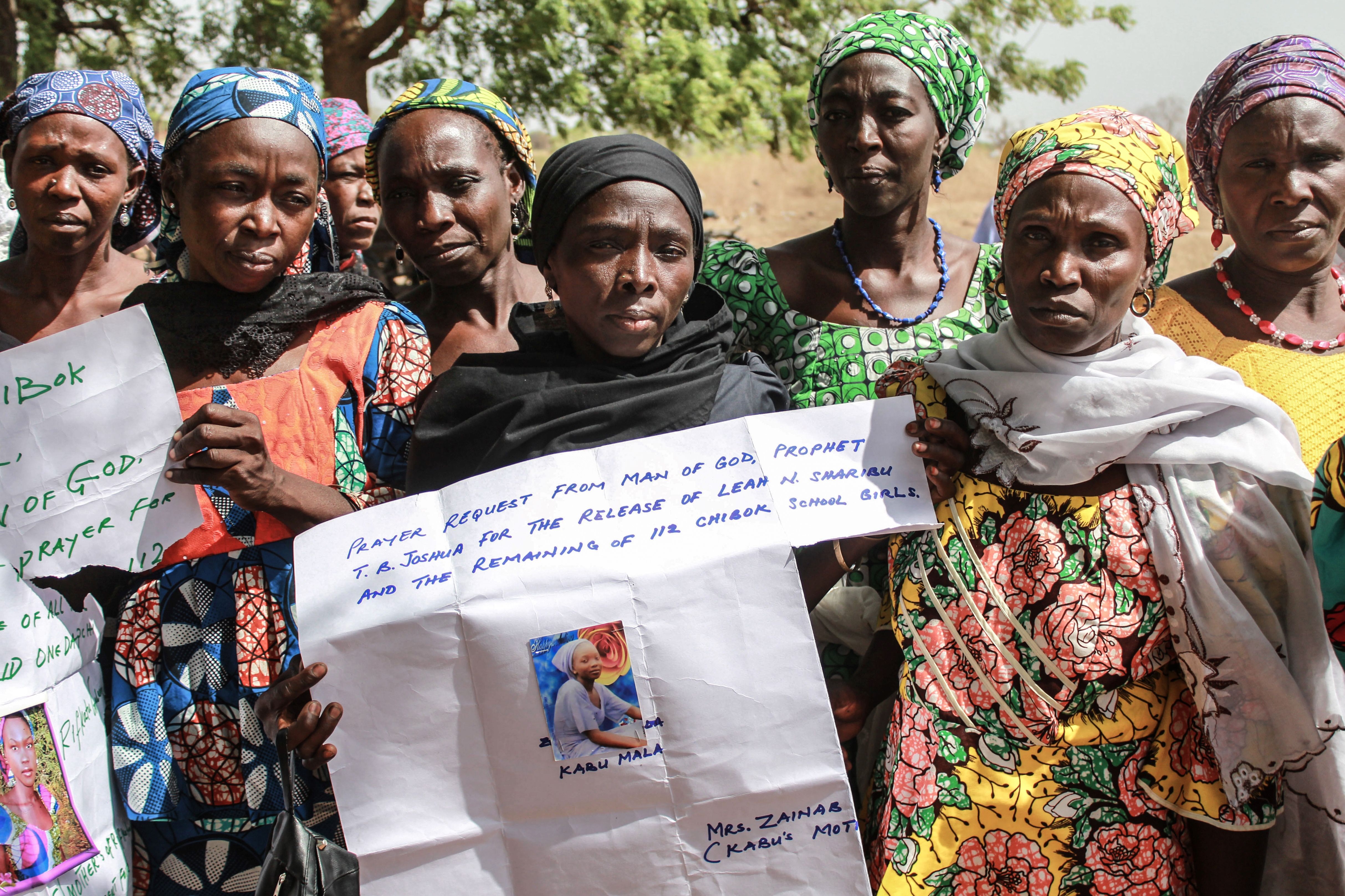 Mothers of abducted Chibok girls hold their daughters’ photographs during a commemoration in northeast Nigeria, 14 April 2019
