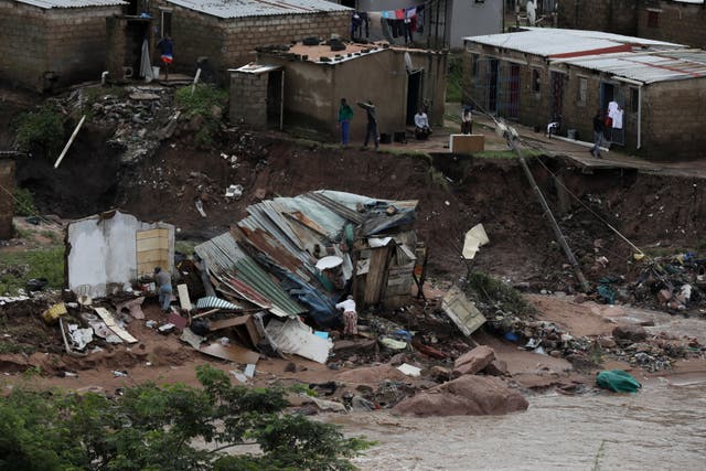<p>A family sifts through what remains of their home after flood waters destroyed it, Durban, South Africa, 12 April 2022</p>
