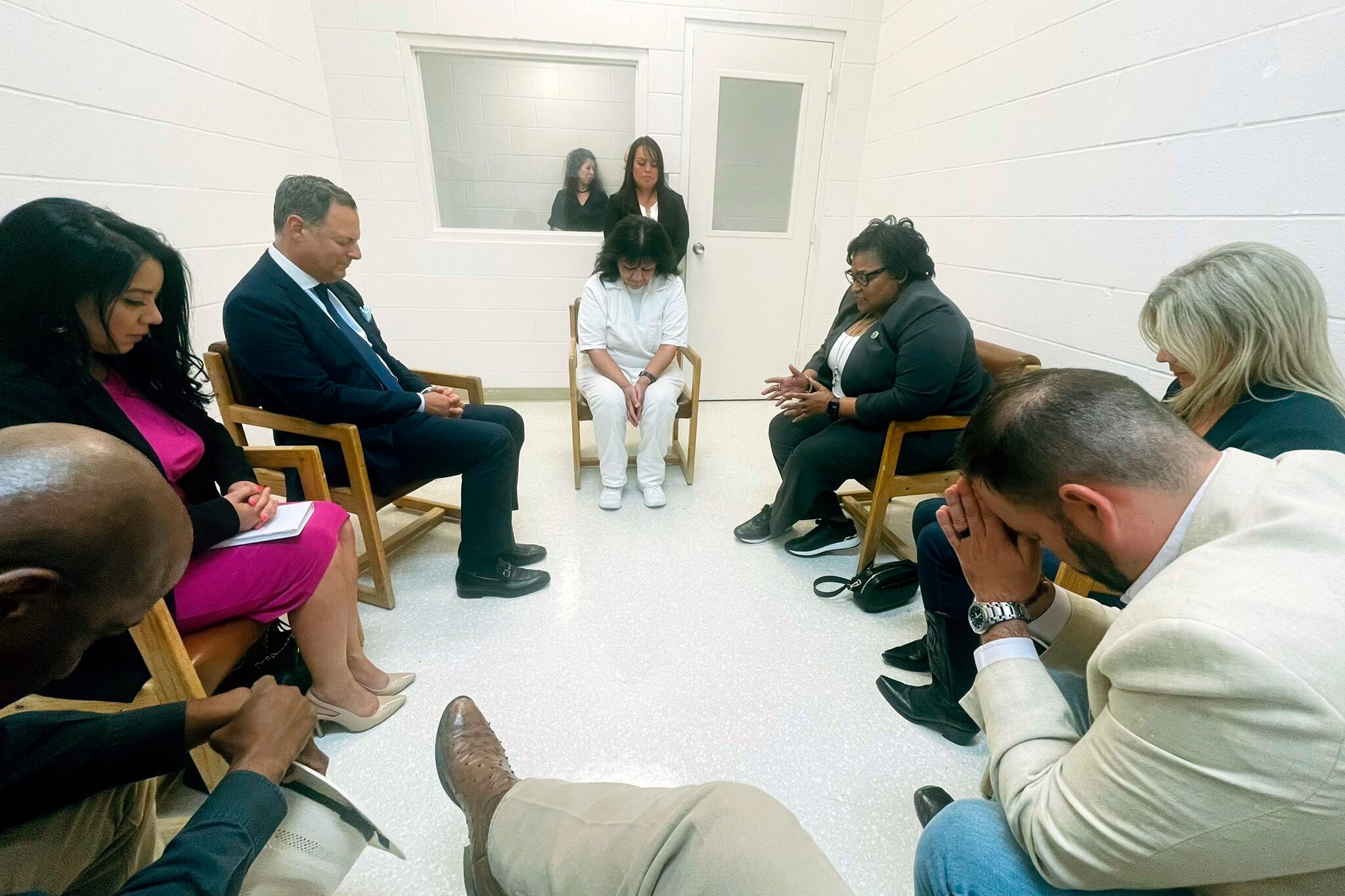 In this April 6, 2022 photo provided by Texas state Rep. Jeff Leach, Texas death row inmate Melissa Lucio, dressed in white, leads a group of seven Texas lawmakers in prayer in a room at the Mountain View Unit in Gatesville, Texas