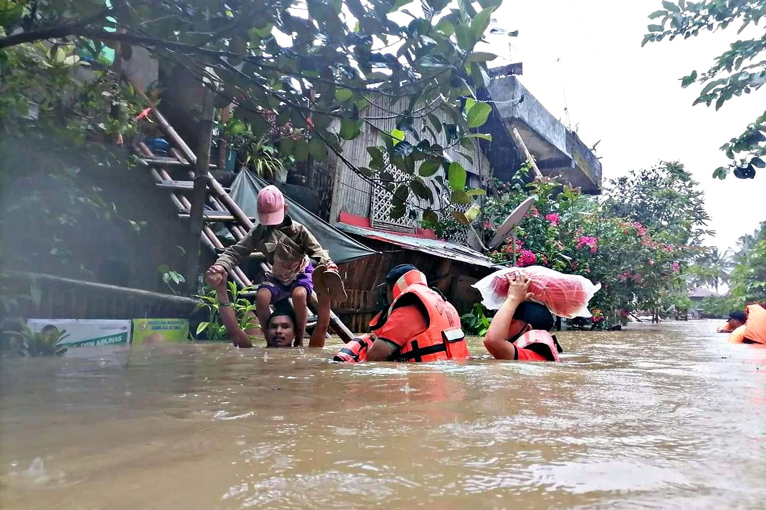 Philippine Coast Guard shows coast guard personnel evacuating local residents