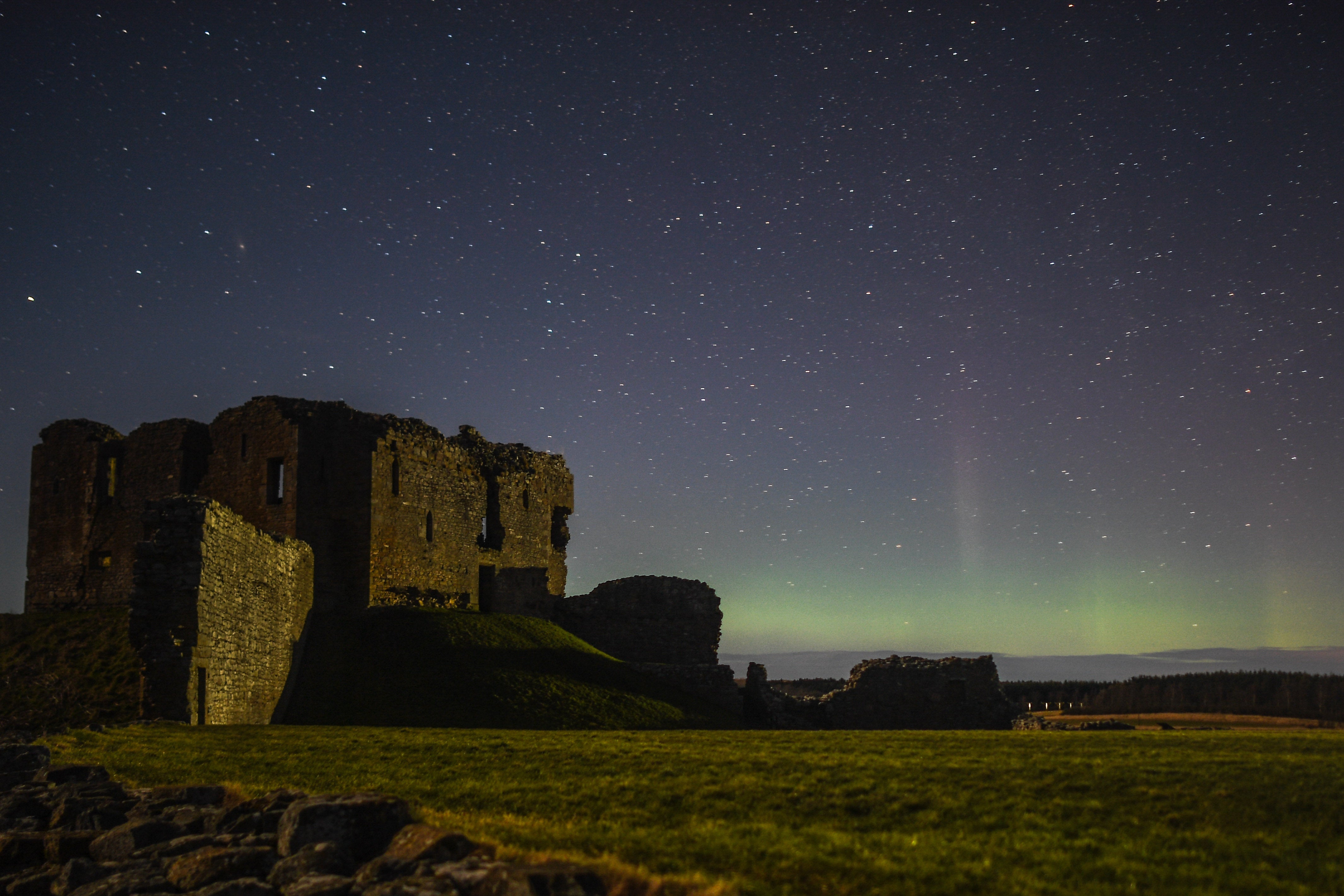 <p>The aurora borealis is seen beyond the ruins of Duffus Castle on 20 February 2021</p>