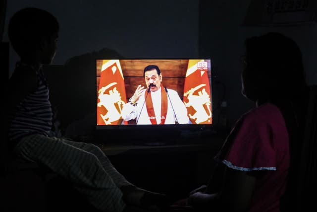 <p>People watch Sri Lankan PM Mahinda Rajapaksa addressing the nation on television in Colombo on 11 April</p>