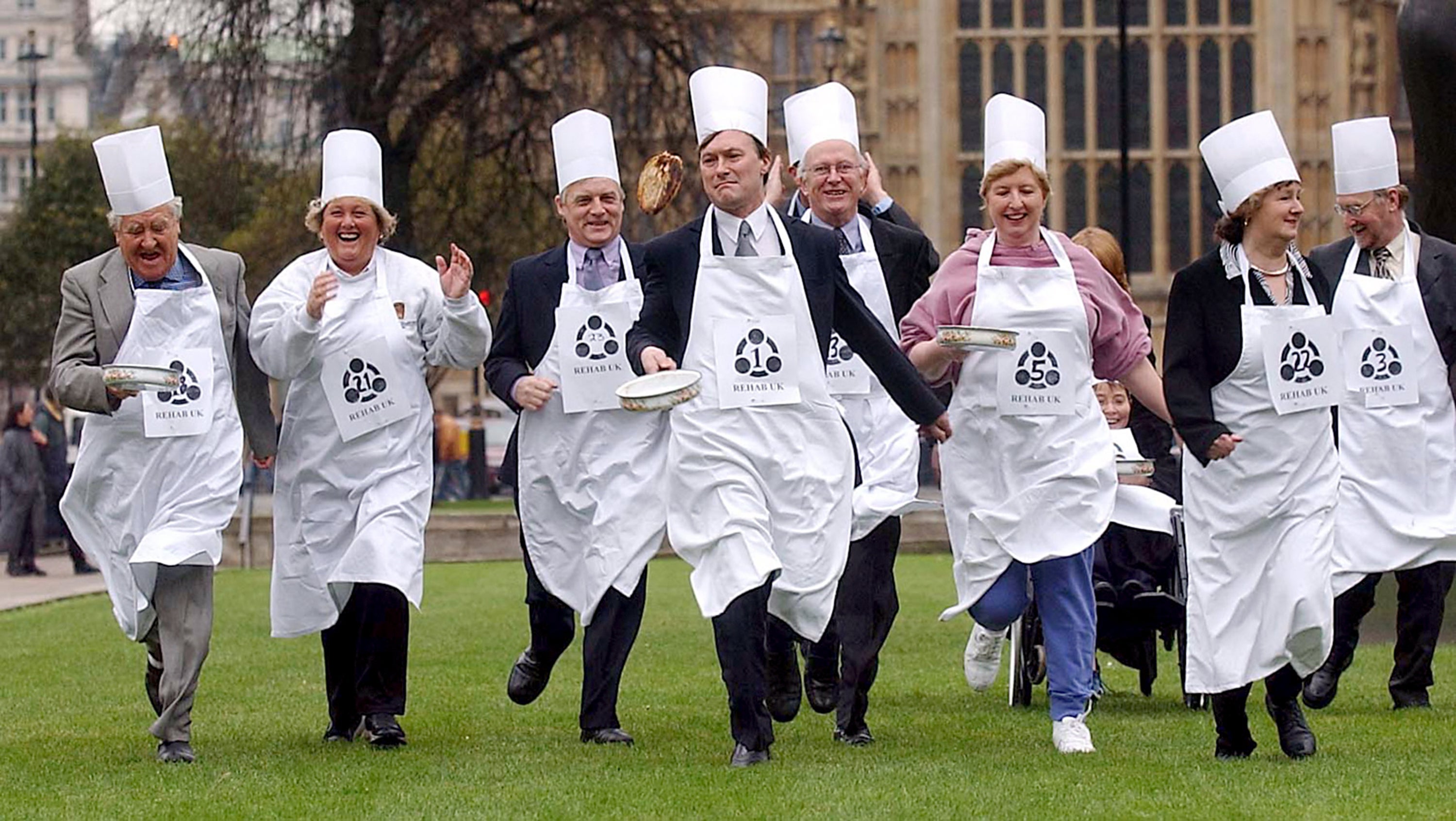 David Amess MP (4th left) leads the way as members of the House of Commons and the House of Lords battle it out in a pancake race yards from Parliament