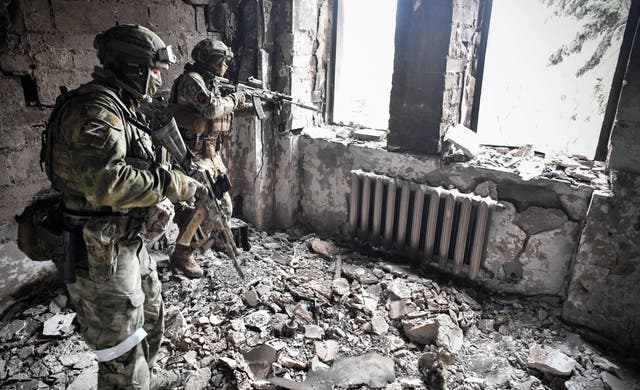 <p>Two Russian soldiers patrol in Mariupol as troops intensify a campaign to take the strategic port city</p>