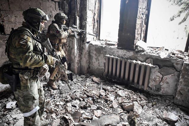 <p>Two Russian soldiers patrol in Mariupol as troops intensify a campaign to take the strategic port city</p>