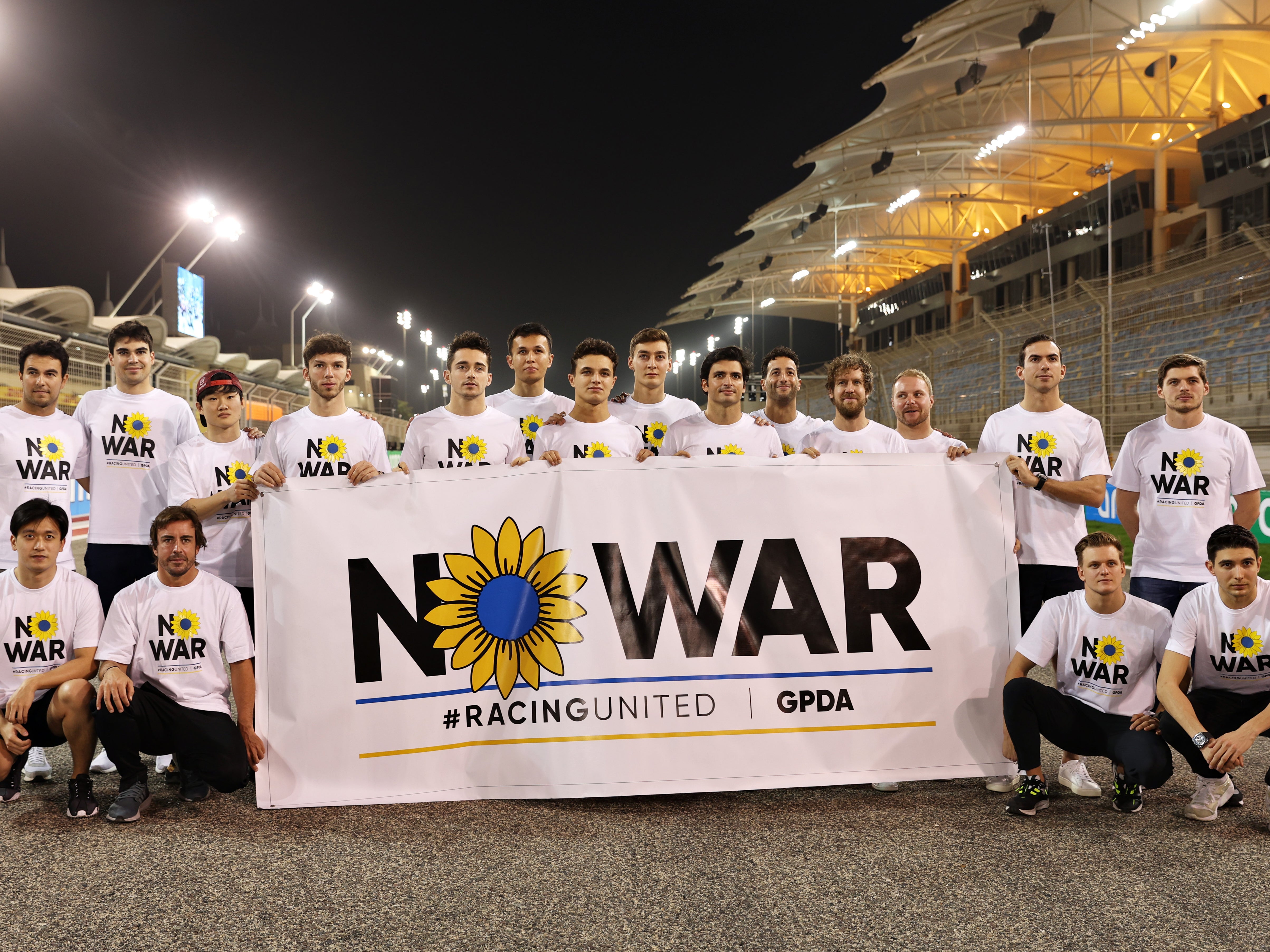 Formula 1 drivers pose with a banner promoting peace and sympathy with Ukraine