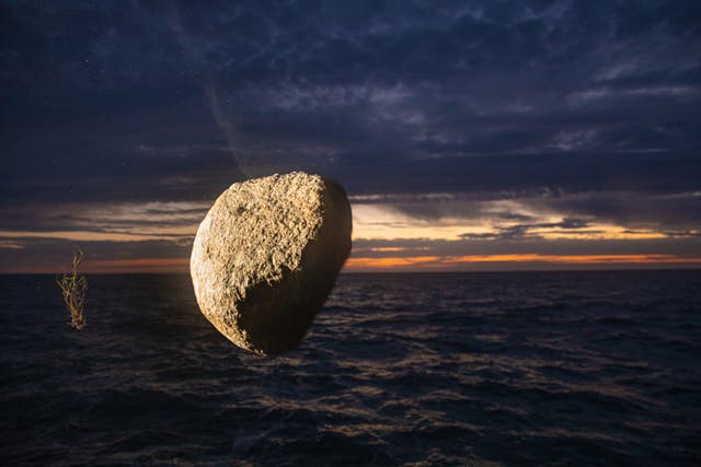A boulder falls into the North Sea from the Greenpeace ship, Esperanza (Suzanne Plunkett / Greenpeace/PA)