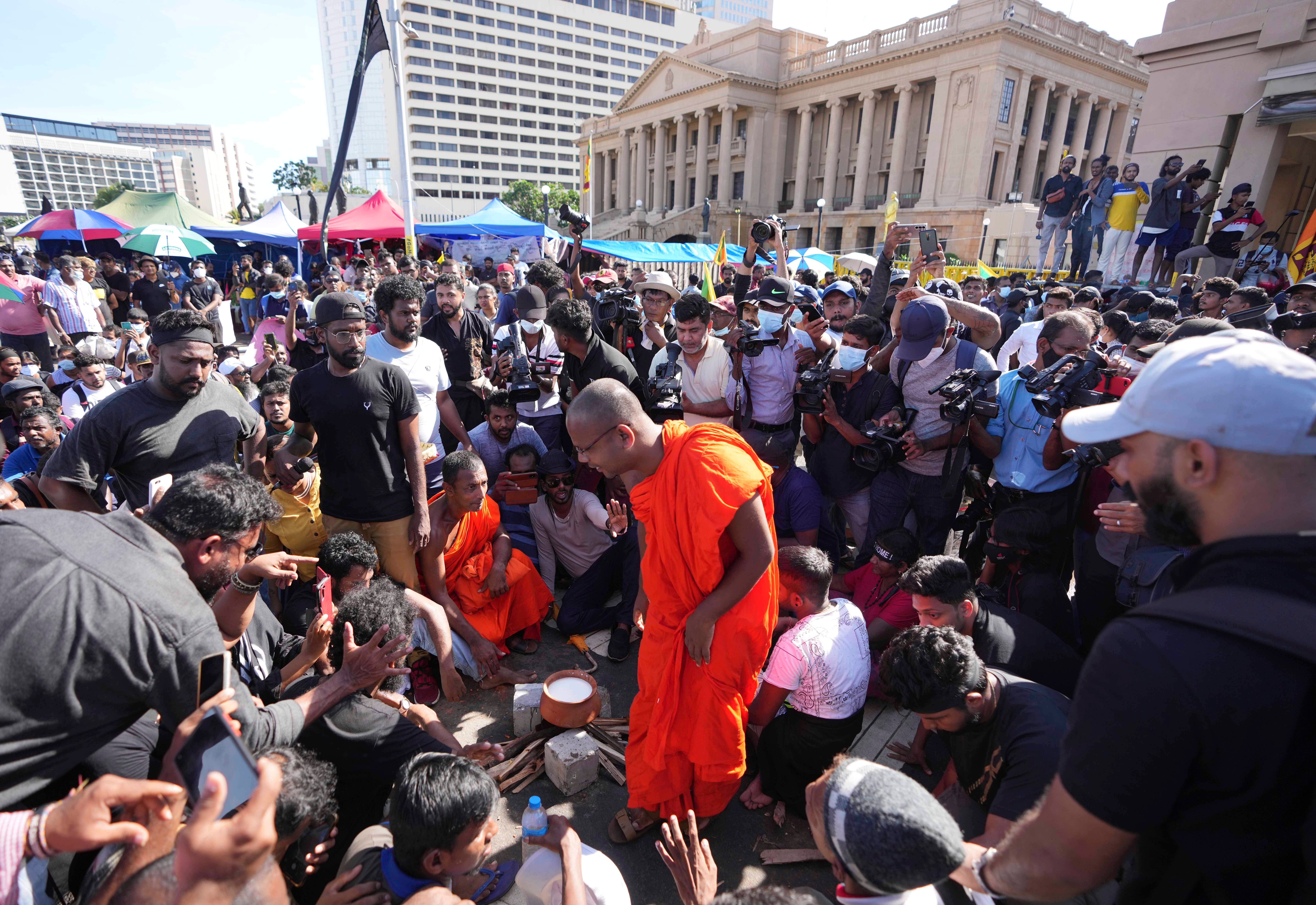 <p>Sri Lankans boil a pot of milk as is customary to welcome the dawn of Sinhalese and Tamil new year at a protest site near the president's office in Colombo on 14 April</p>