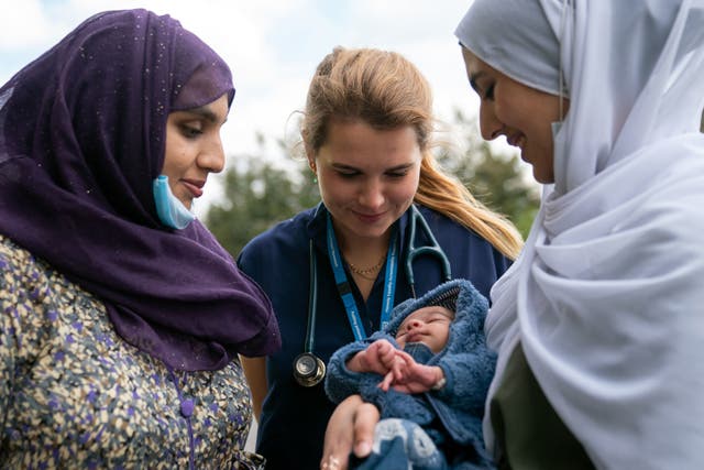<p>Accident and emergency registrar Ewa Grocholksi (centre) with two-week-old baby Mohammed Ibrahim and his mother Lalene Malik (left) and auntie Adina Malik (right) at Northwick Park Hospital in Harrow</p>