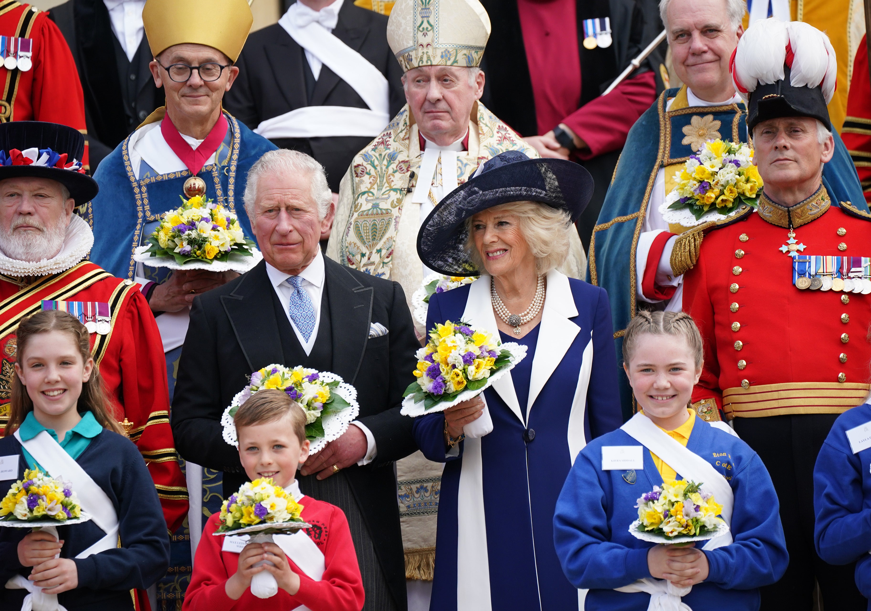 The Prince of Wales, representing the Queen, and the Duchess of Cornwall pose for a photograph with members of the Queen’s Body Guard of the Yeomen of the Guard, following the Royal Maundy Service at St George’s Chapel, Windsor. Picture date: Thursday April 14, 2022.