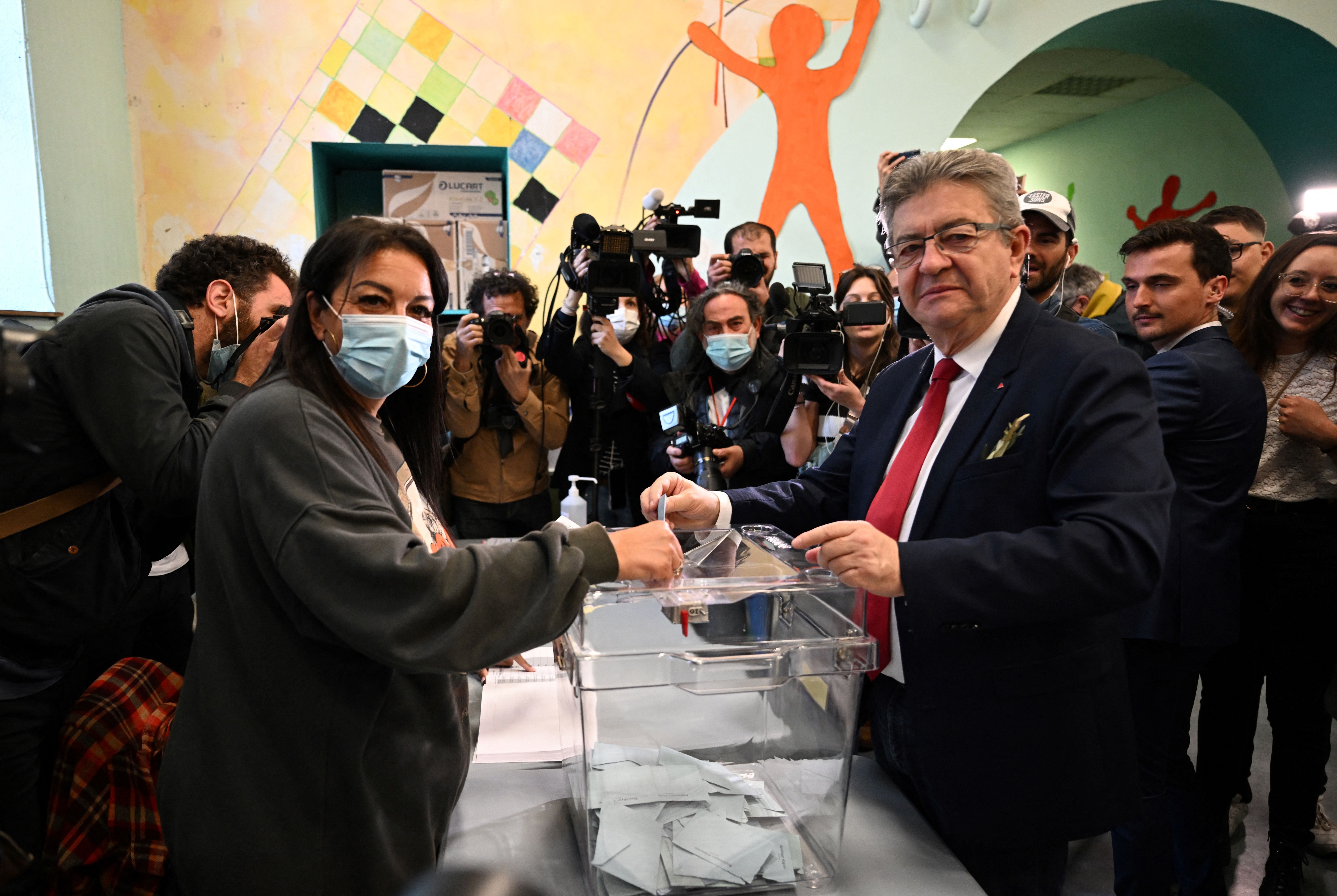 Jean-Luc Melenchon (R) casts his ballot for the first round of France’s presidential election at a polling station in Marseille